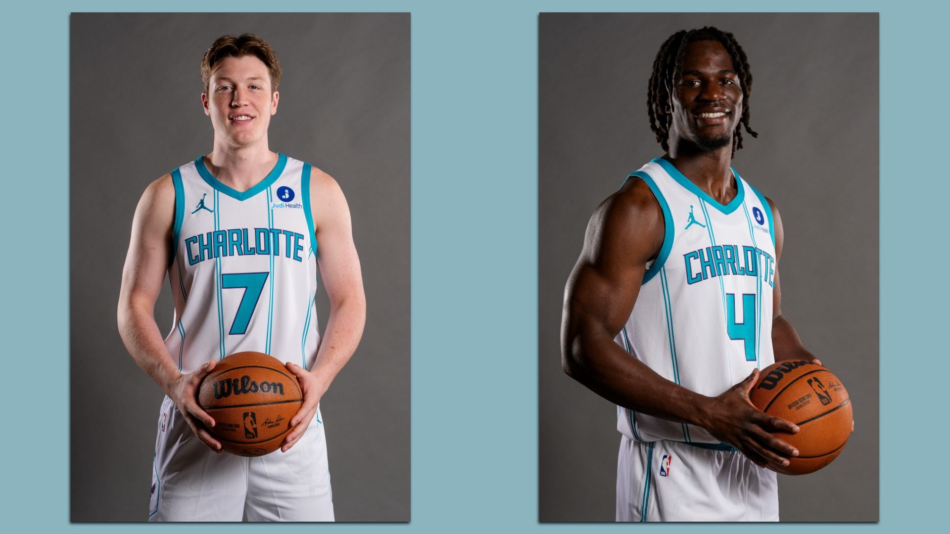 Two Charlotte Hornets basketball players pose wearing white jerseys with teal trim. The player on the left, wearing number 7, holds a basketball in front of him and smiles at the camera. The player on the right, wearing number 4, also holds a basketball and smiles while facing slightly to the side.