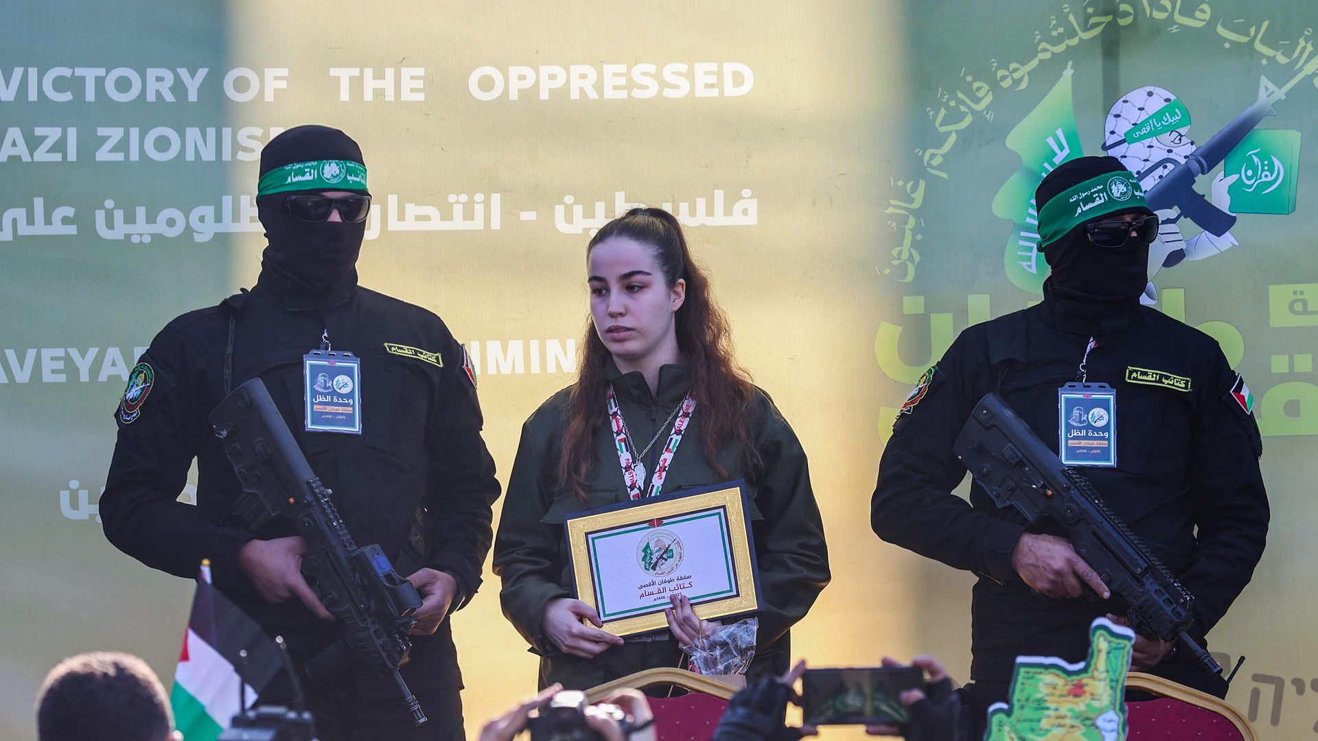 Image shows Hamas militants escorting Israeli hostage Agam Berger before handing her over to a Red Cross team. 