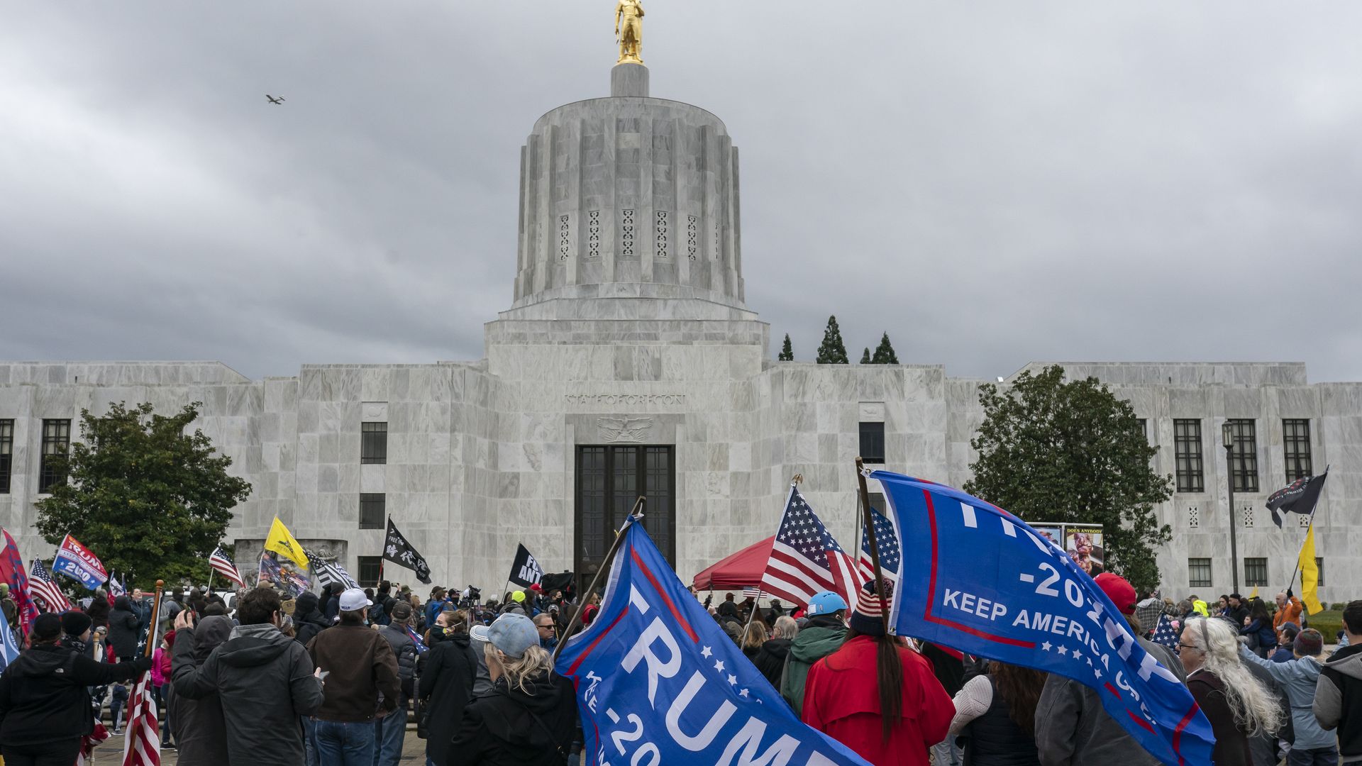 Picture of the Oregon State Capitol building in January, with pro-Trump protestors standing outside.