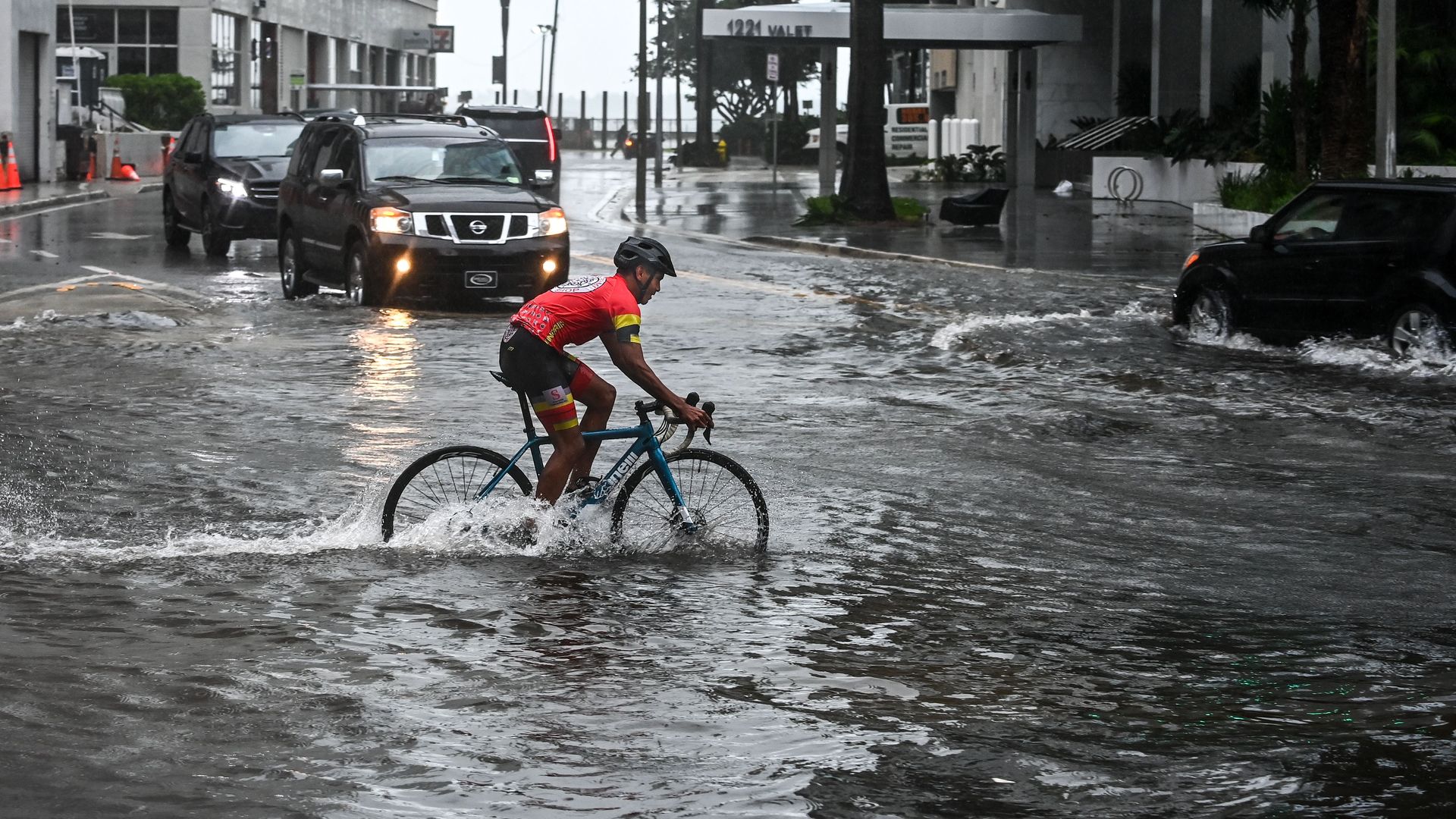 A cyclist rides through the flooded street during heavy rain and wind as tropical storm Eta approaches the south of Florida, in Miami, Florida on November 9