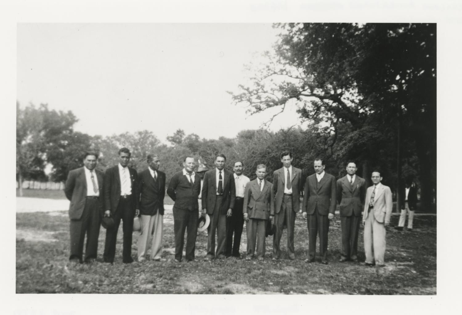 A group of men in black-and-white in a park.