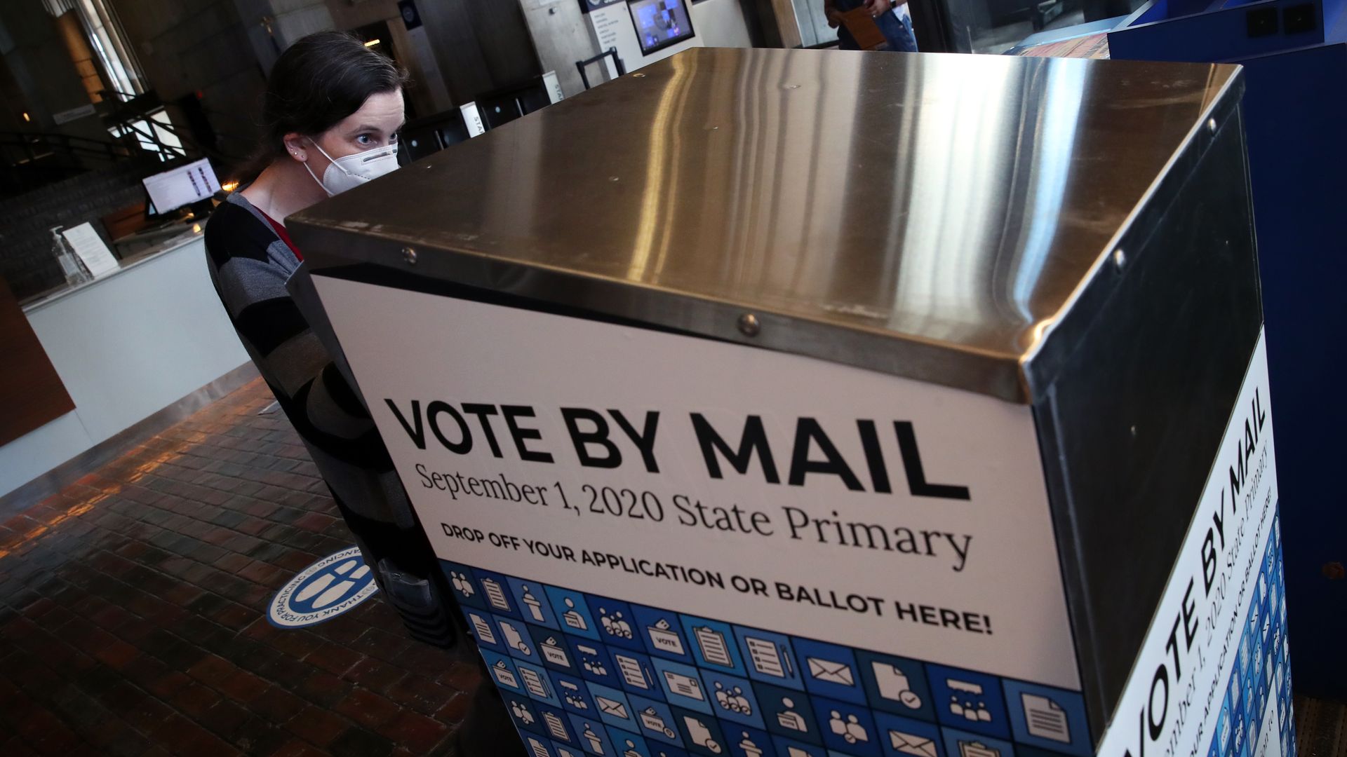 A woman drops off her mail-in ballot at City Hall in Boston during the primary election on Sept. 1, 2020.
