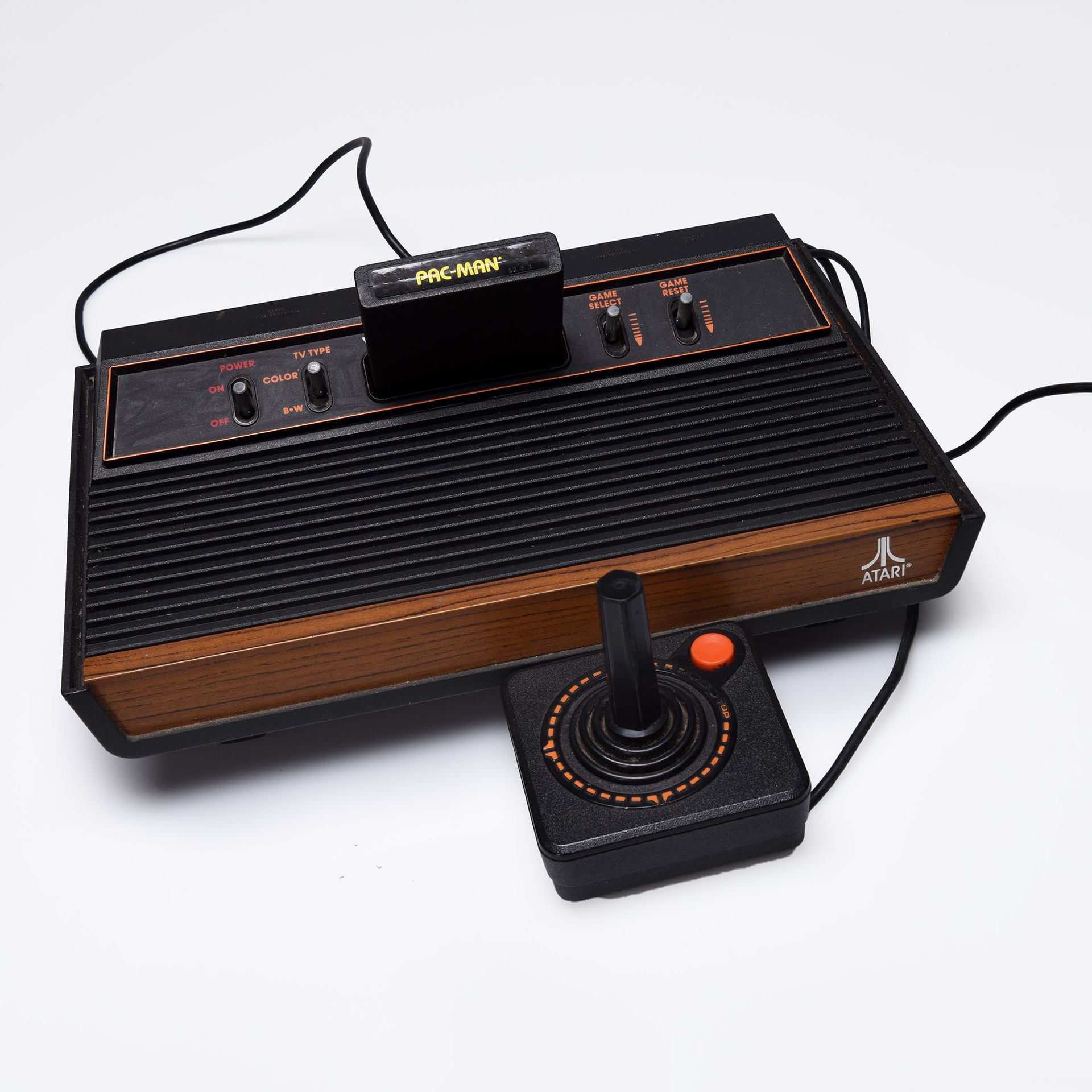 Photo of a black and brown video game console with a controller attached
