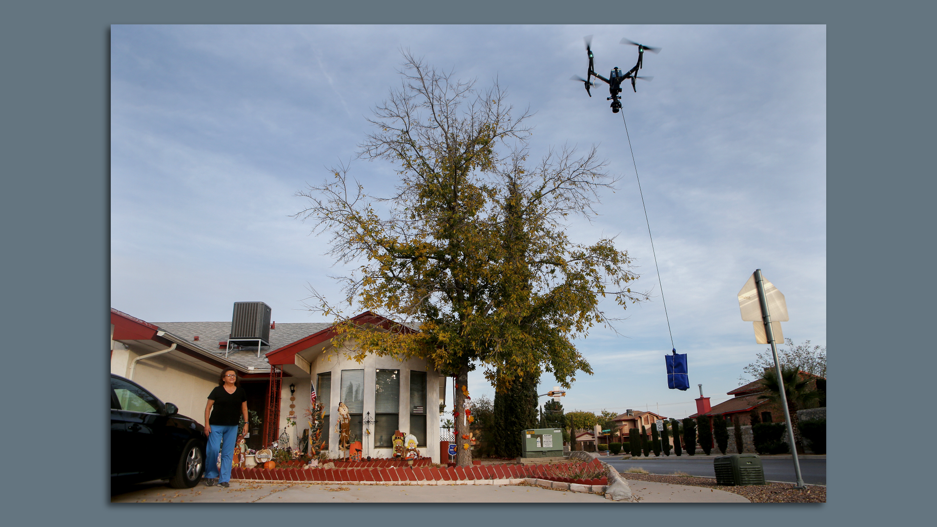 A resident of El Paso, Texas awaits a drone delivery outside her home.