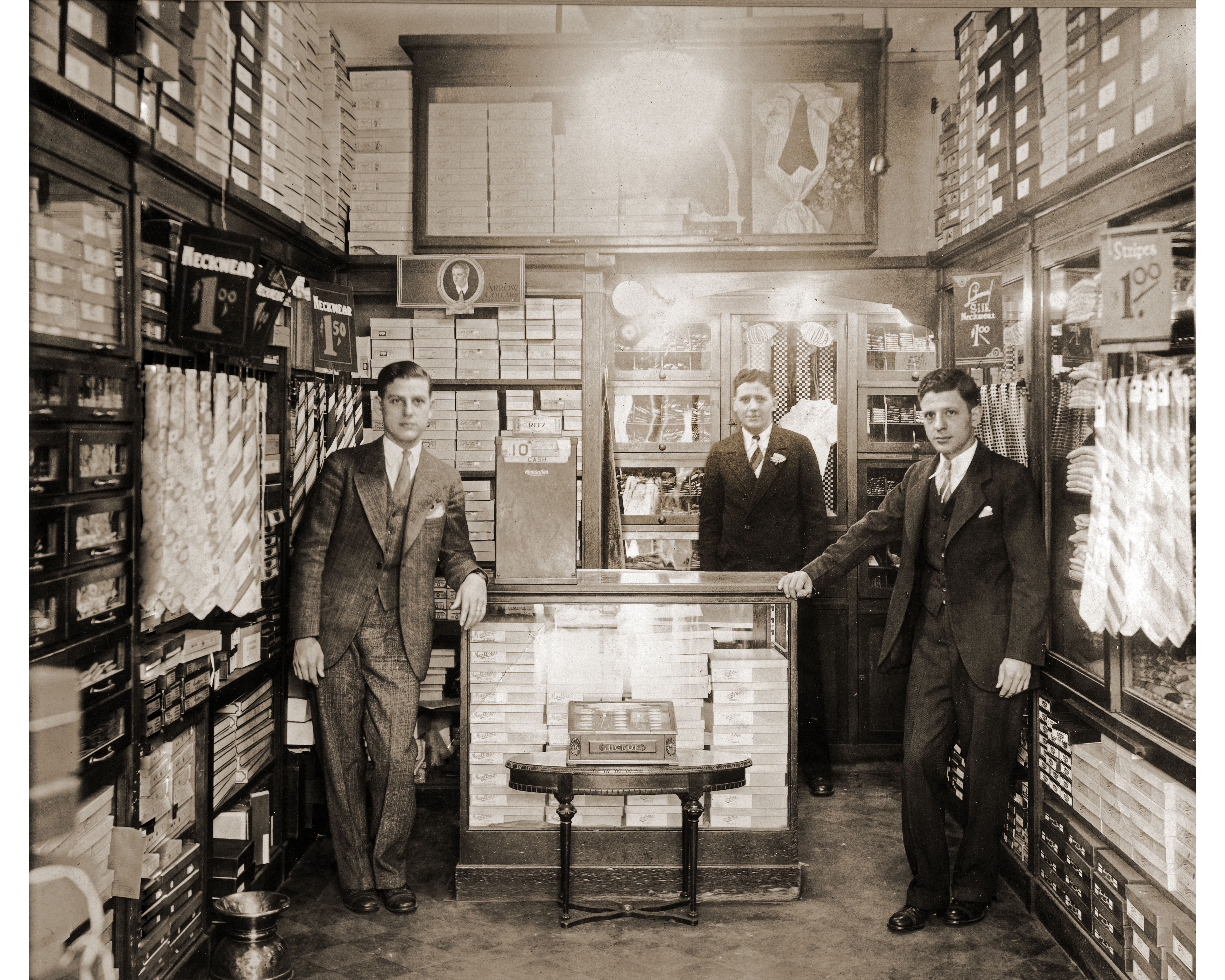 In a black and white photo, Morris, Elkin and Sam Rubenstein pose for a photo in a store stockroom.