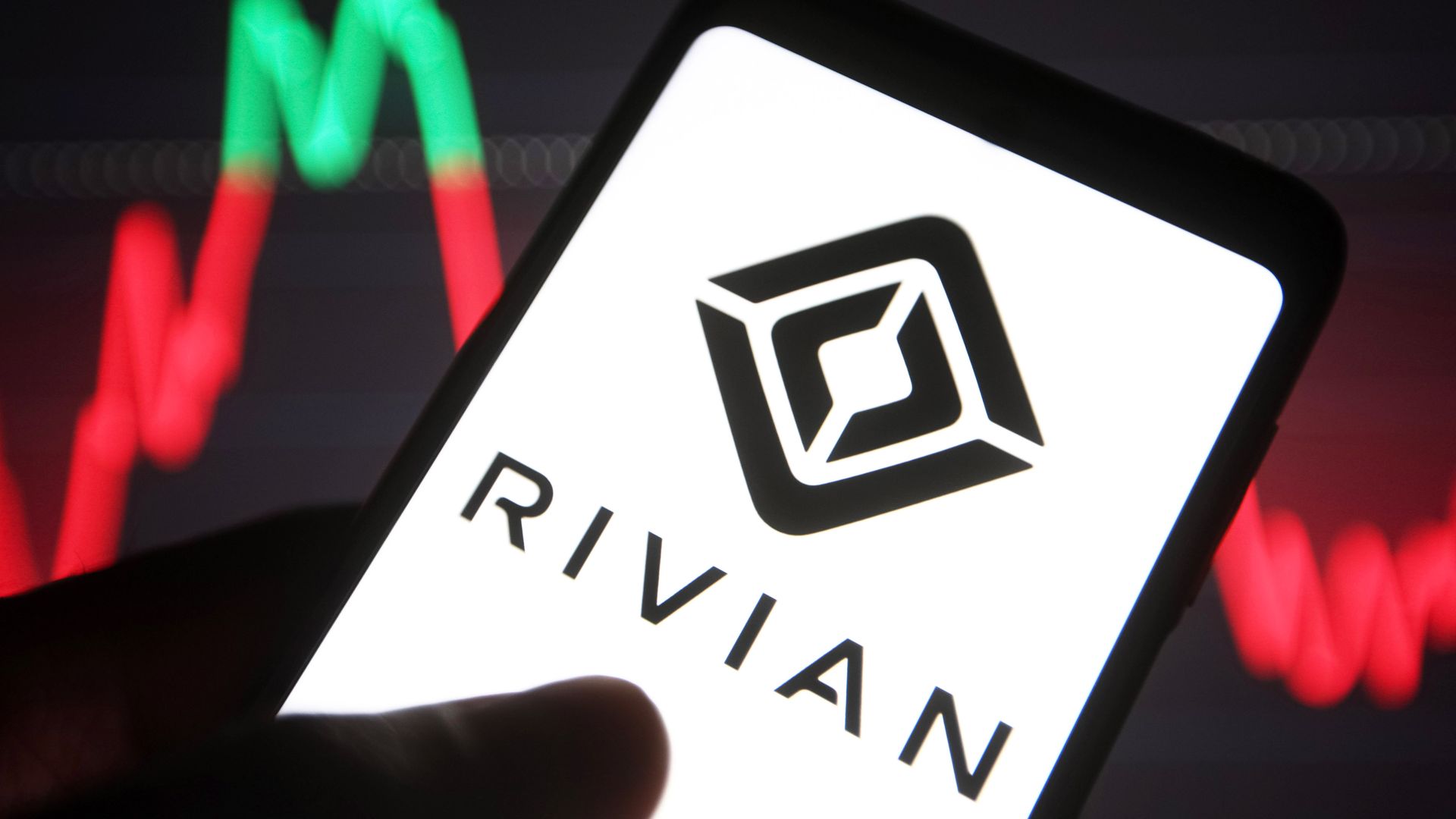 A Rivian Automotive LLC logo of an electric vehicle automaker is seen on a smartphone screen.