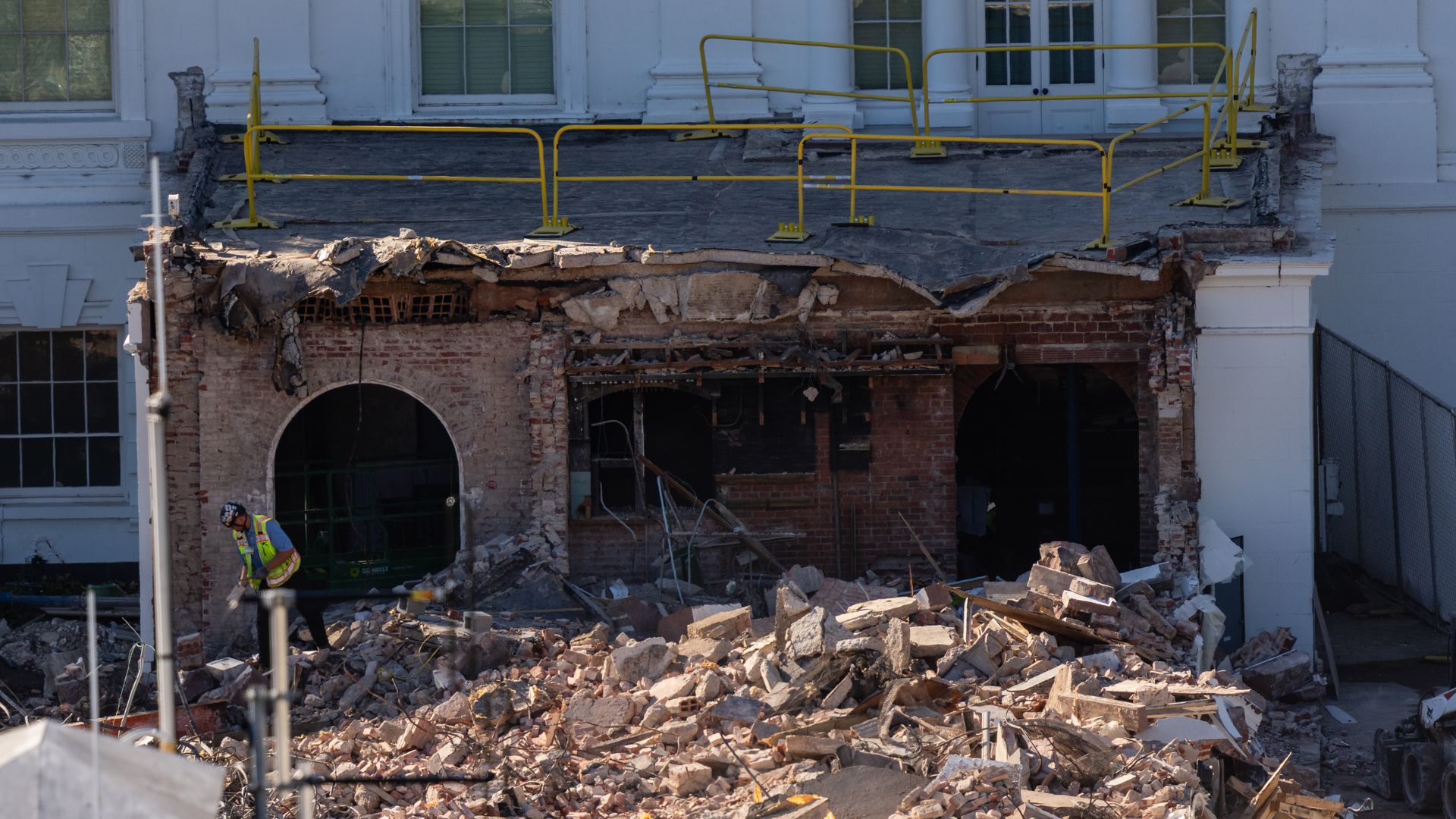 A worker clears rubble from the torn down East Wing. 