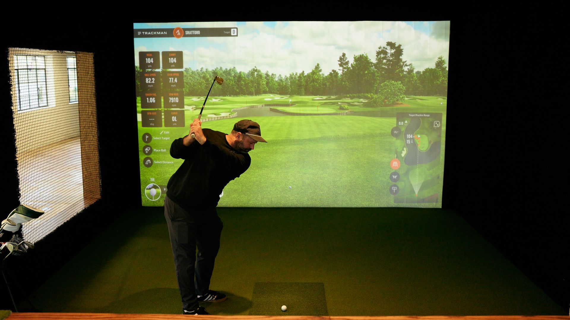 A man plays golf on a simulator