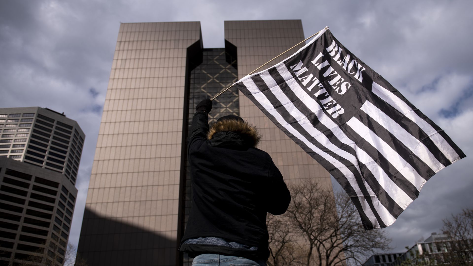 Protester waving flag in front of Hennepin County courthouse
