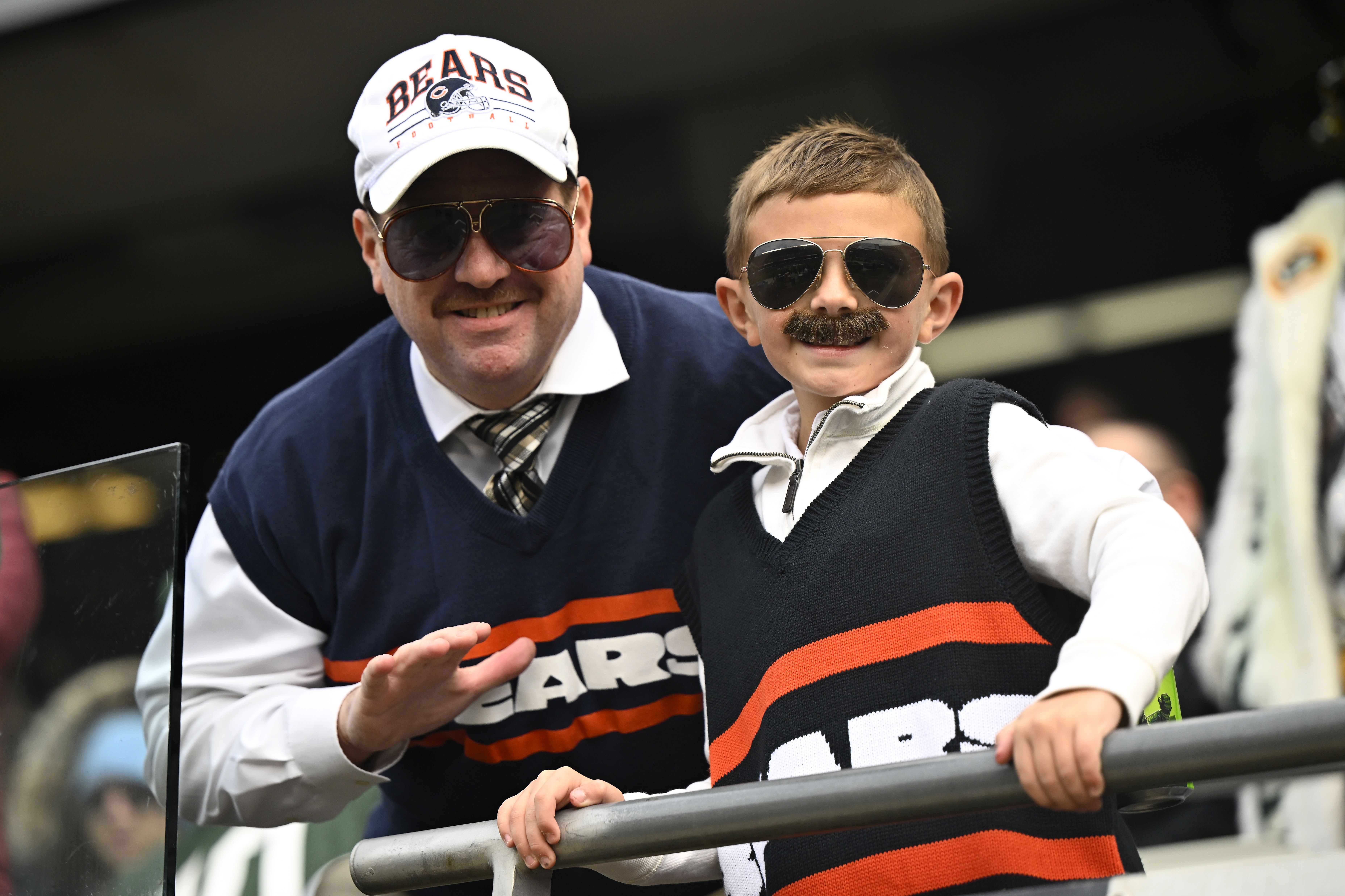 Photo of a man and child wearing fake mustaches and sunglasses and posing for the camera