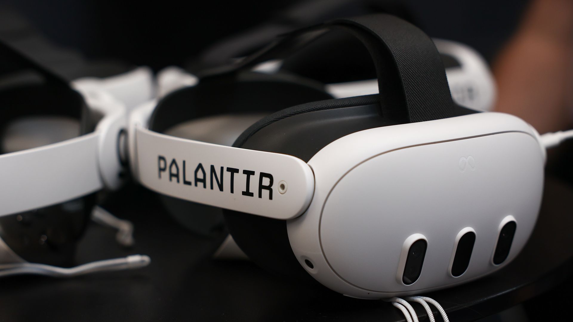 A white virtually simulation goggle with the word PALANTIR on its side. 