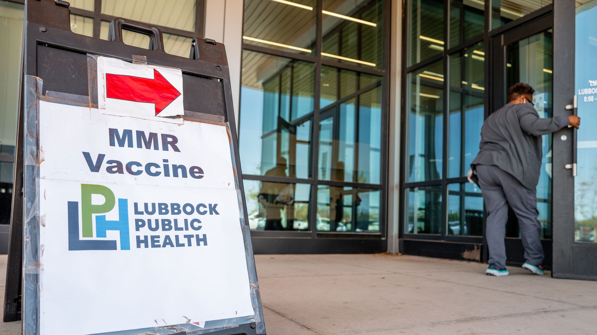 Outdoor sign with red arrow pointing right reading 