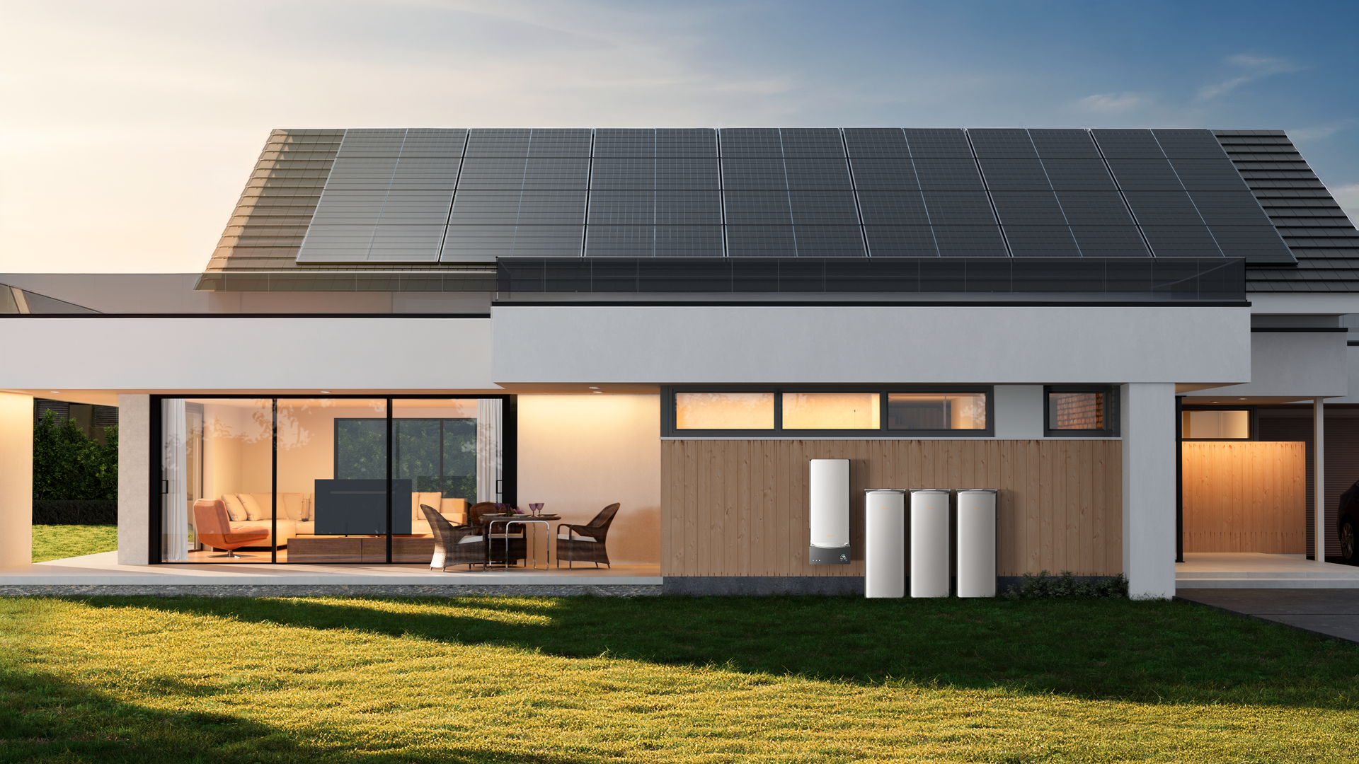 Modern home with rooftop solar panels and outdoor battery storage units at sunset.