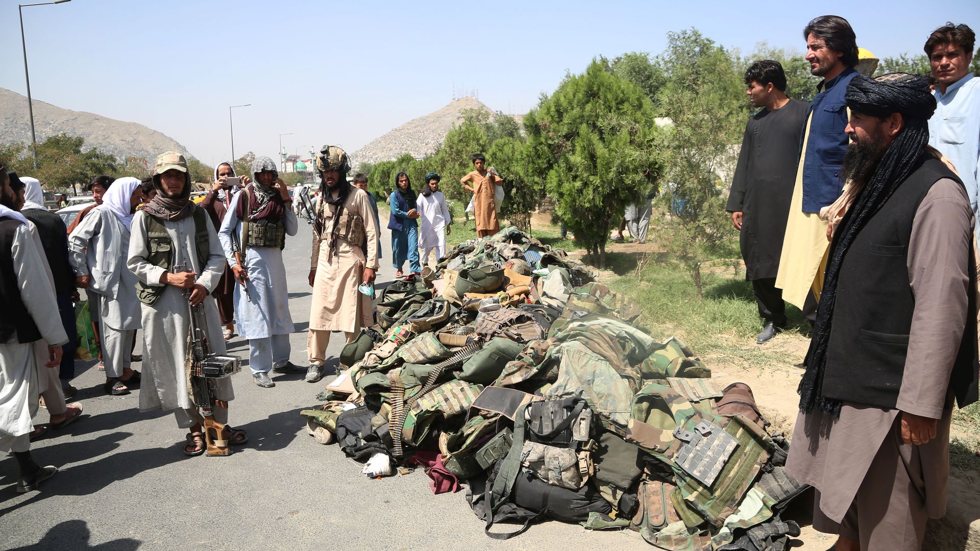 Taliban standing alongside Afghan security force equipment