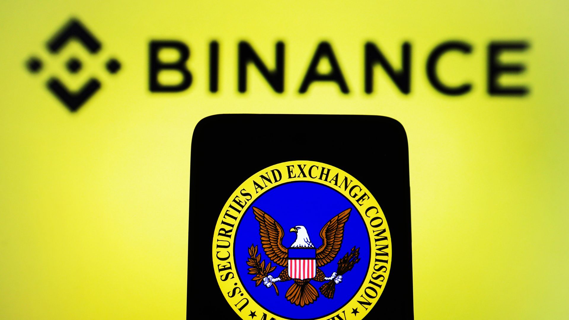 Photo illustration of a Binance logo and the SEC logo.