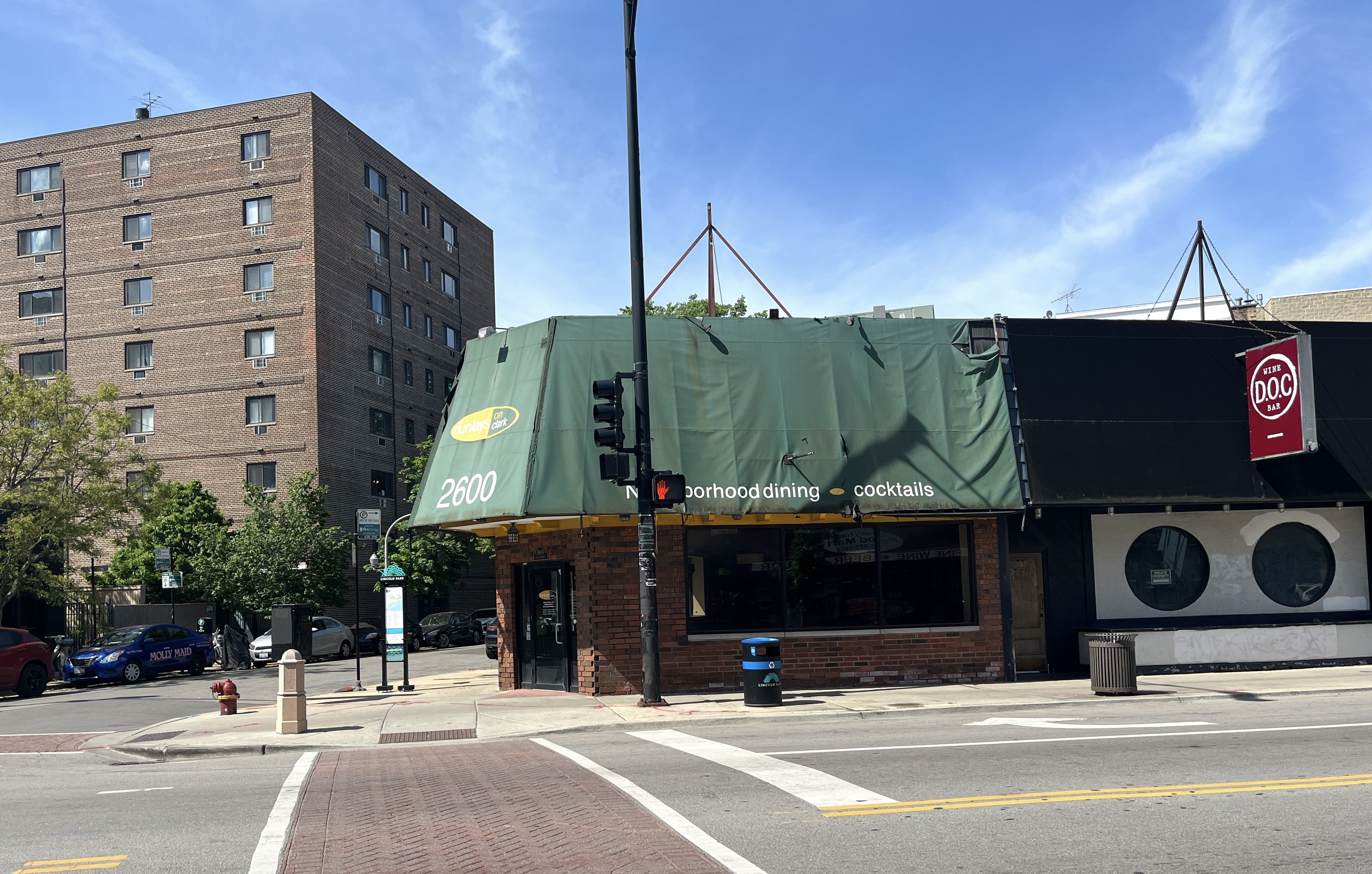 Restaurant on corner with green awning.