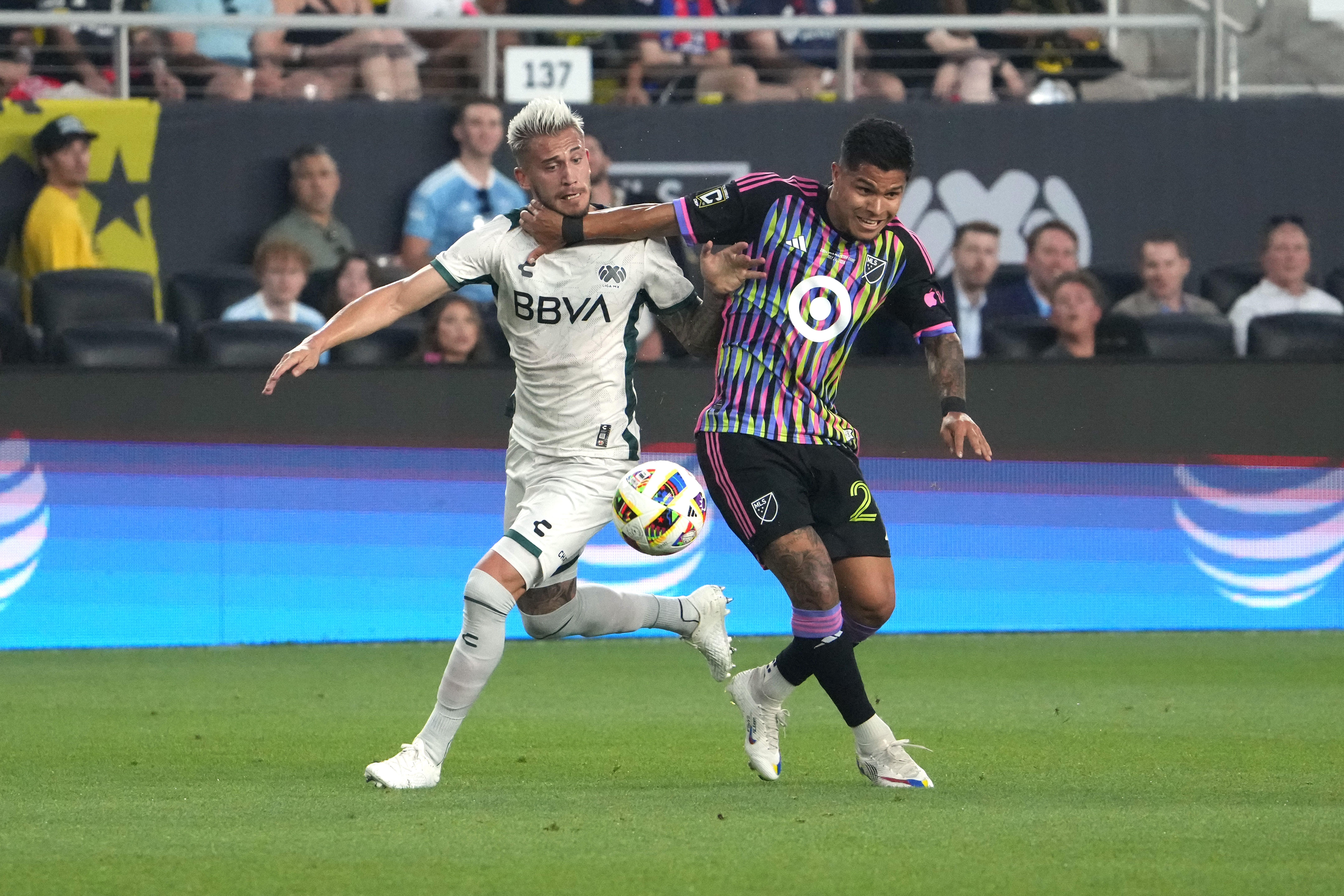 Cucho Hernandez fights for the ball against a Liga MX player