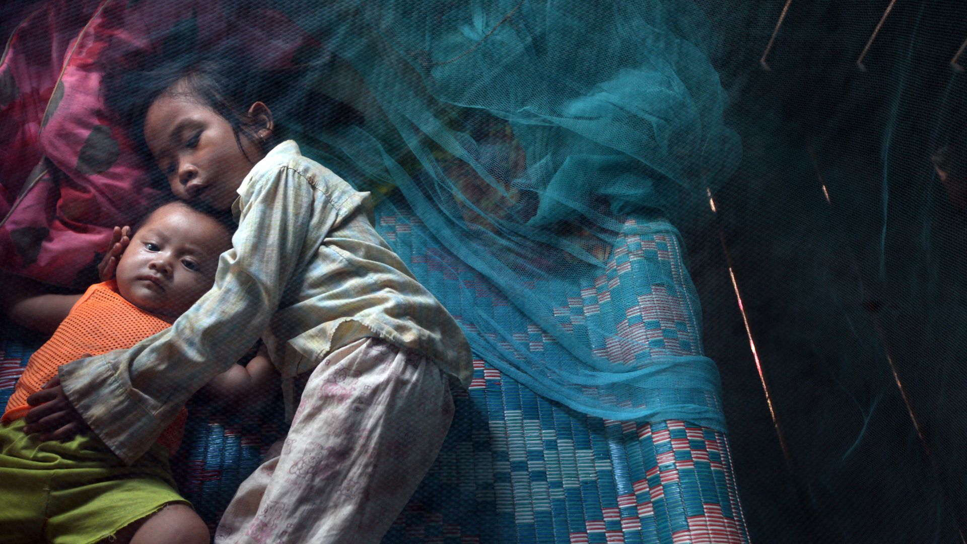 Image of kids underneath bed nets