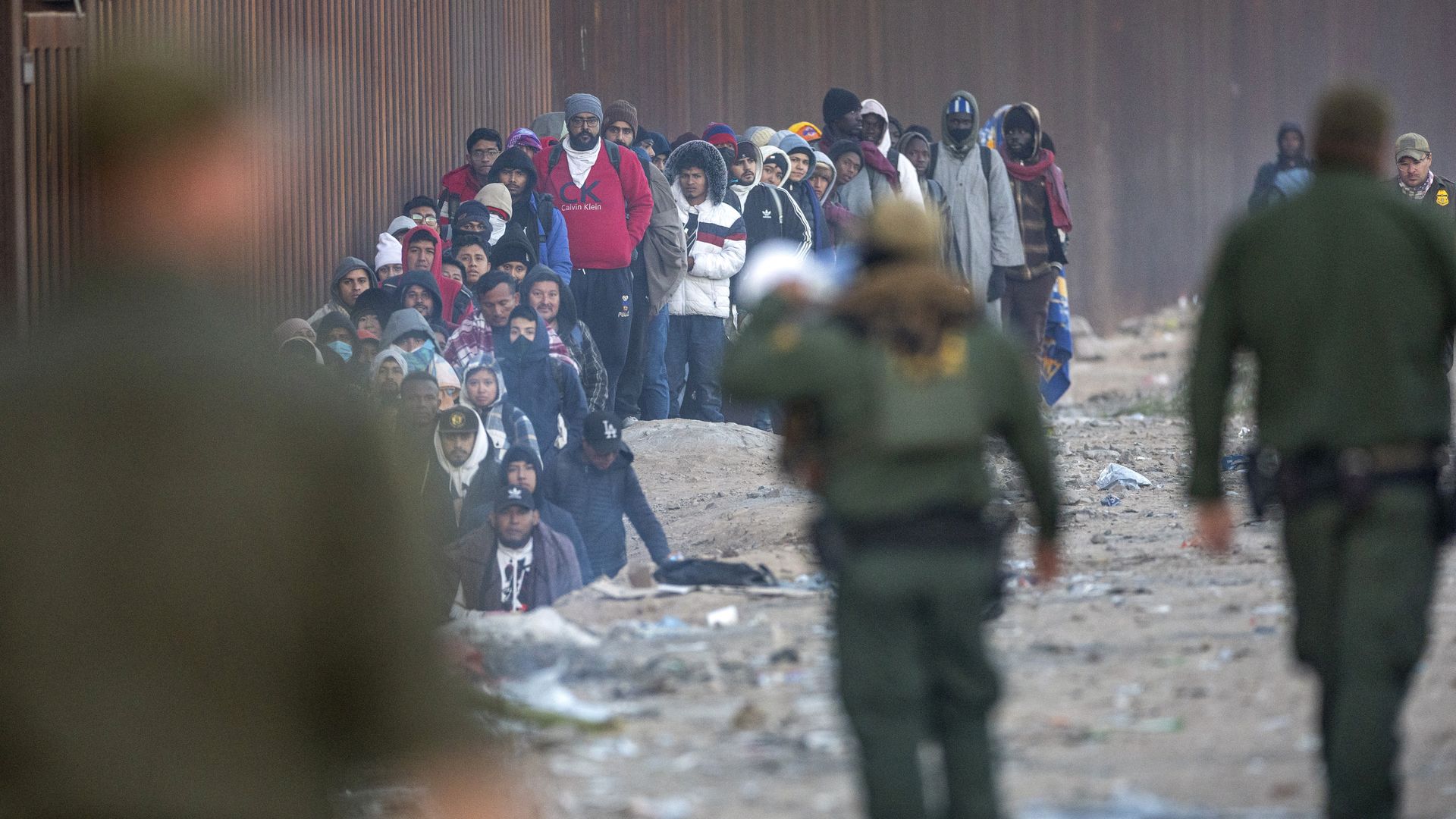 Immigrants, most from Asia and Africa wait to be transported by U.S. Border Patrol agents from the U.S.-Mexico border on December 06, 2023 in Lukeville, Arizona.