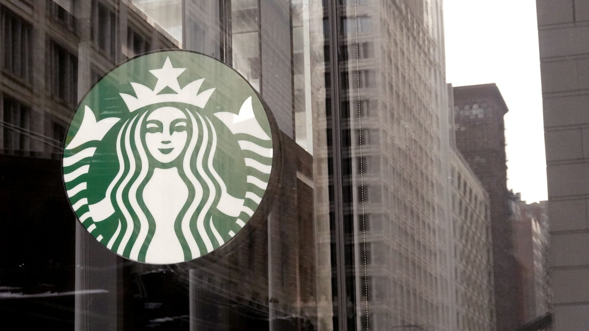 Photo of a Starbucks logo mounted on the exterior of a glass skyscraper
