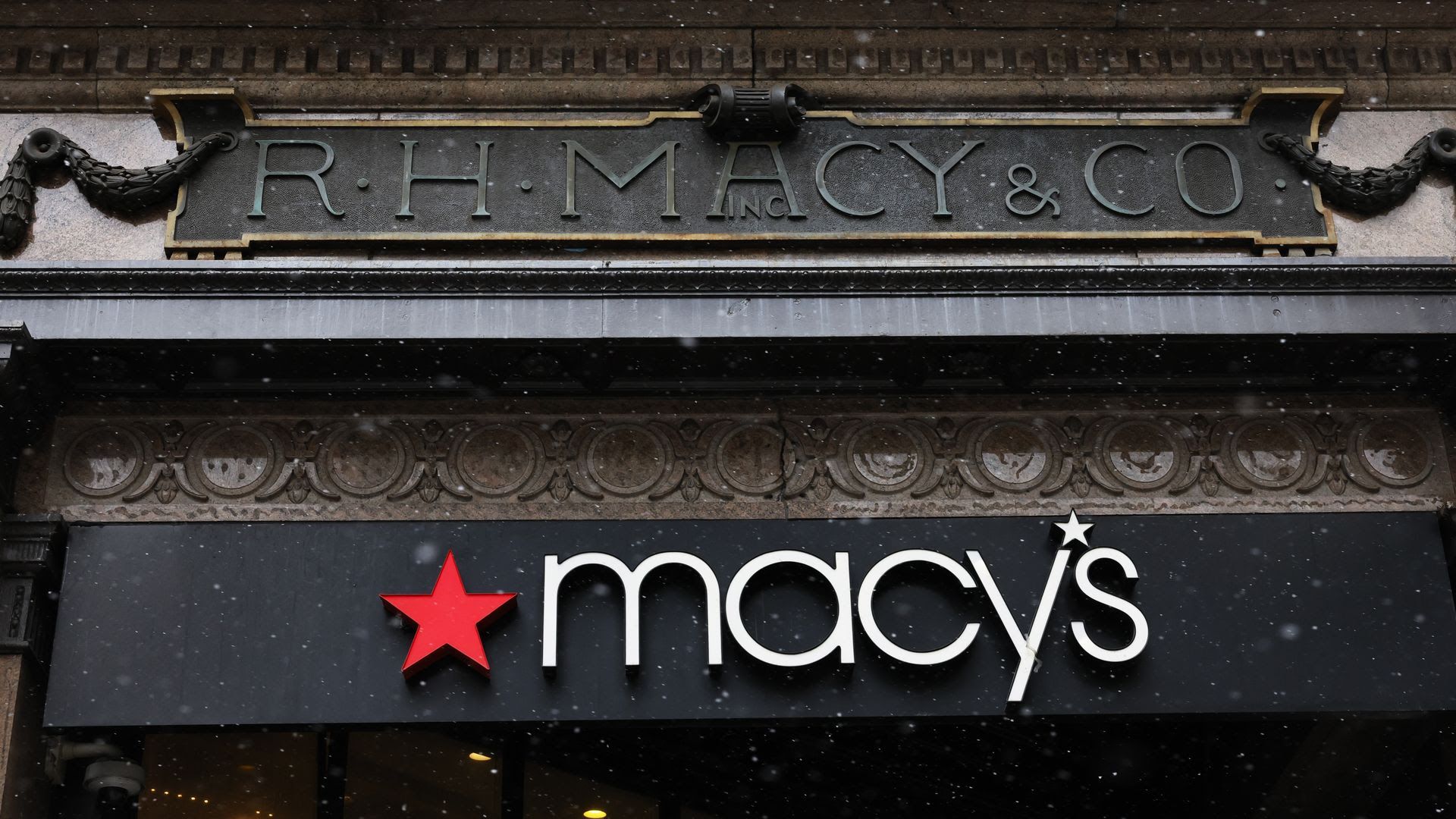 A Macy's sign hangs above the entrance to one of its department stores.