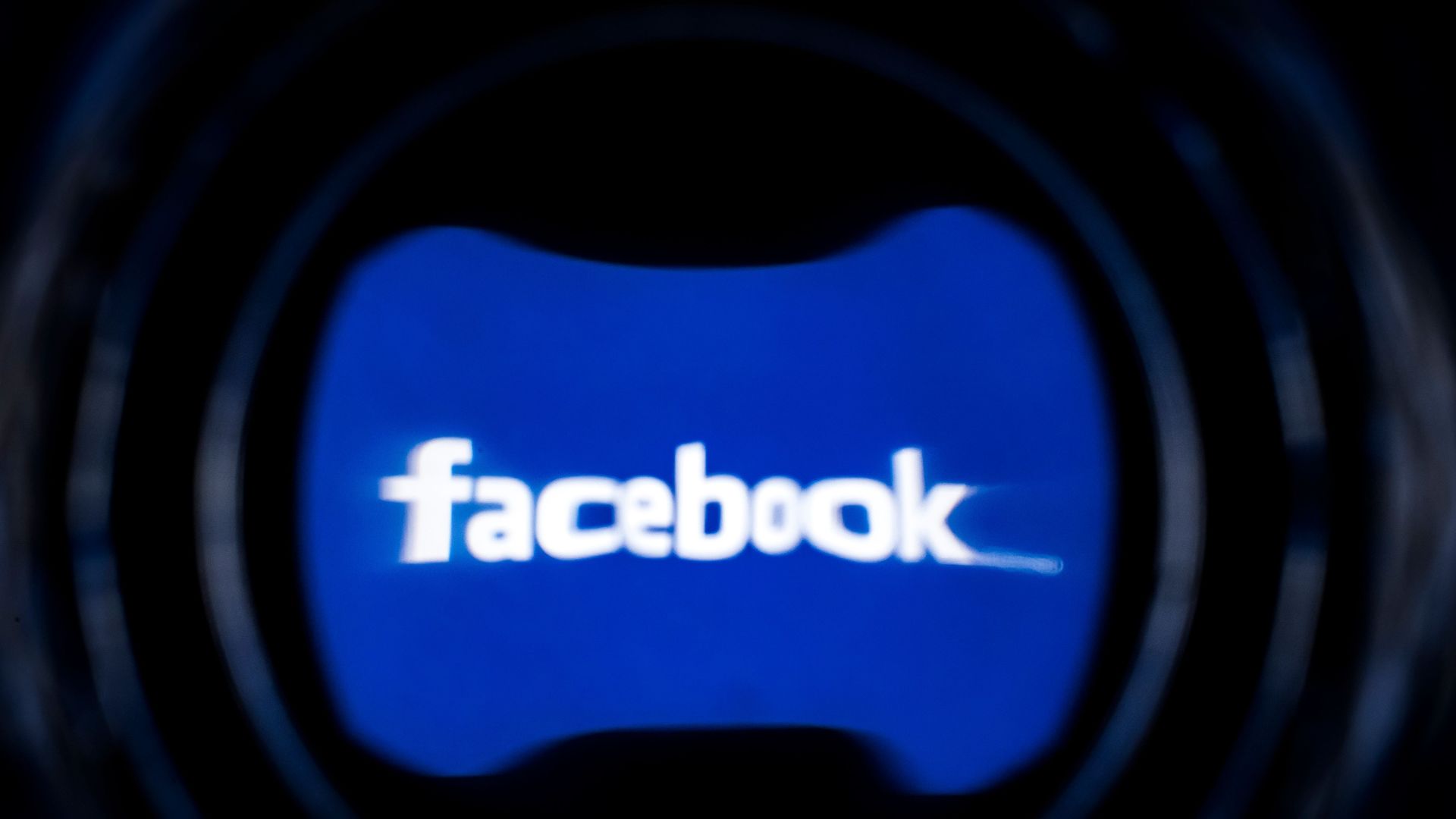 A blurry Facebook logo on a screen
