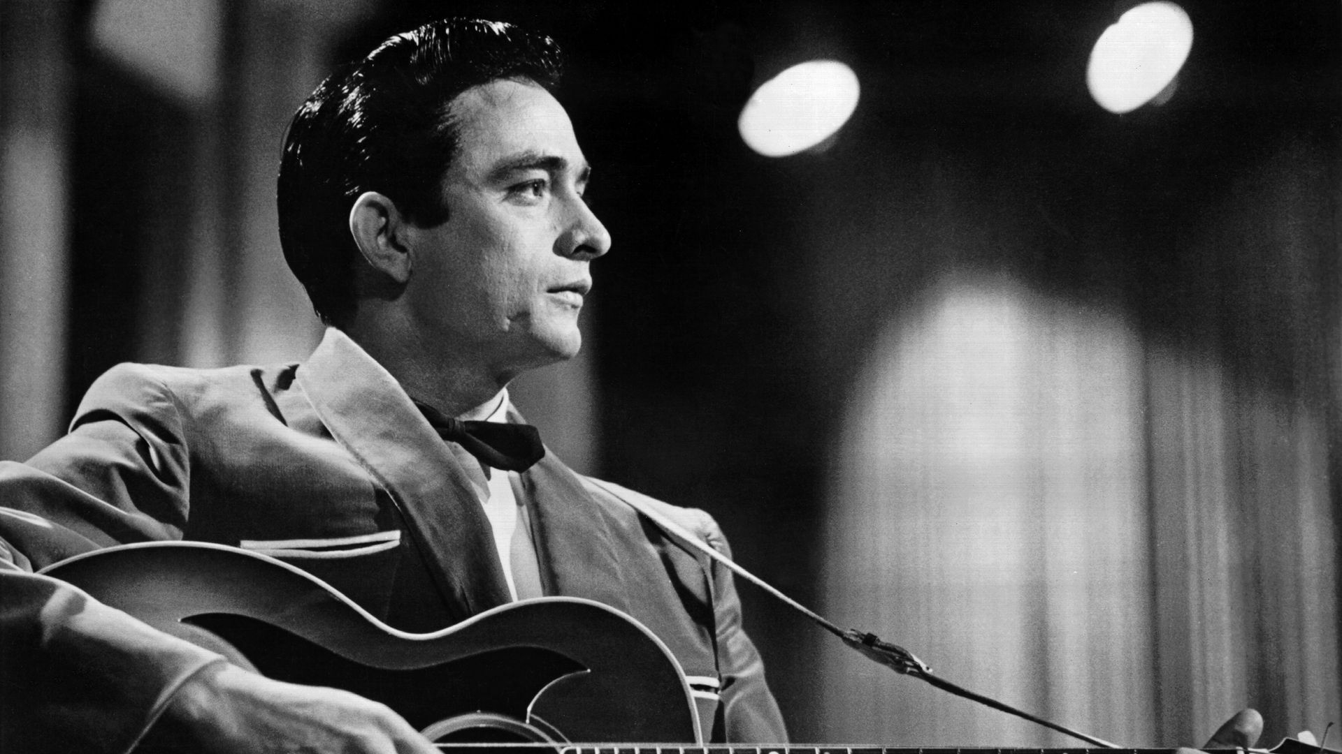 Country singer/songwriter Johnny Cash performs onstage with an acoustic guitar in Sun Records publicity shot in 1957.