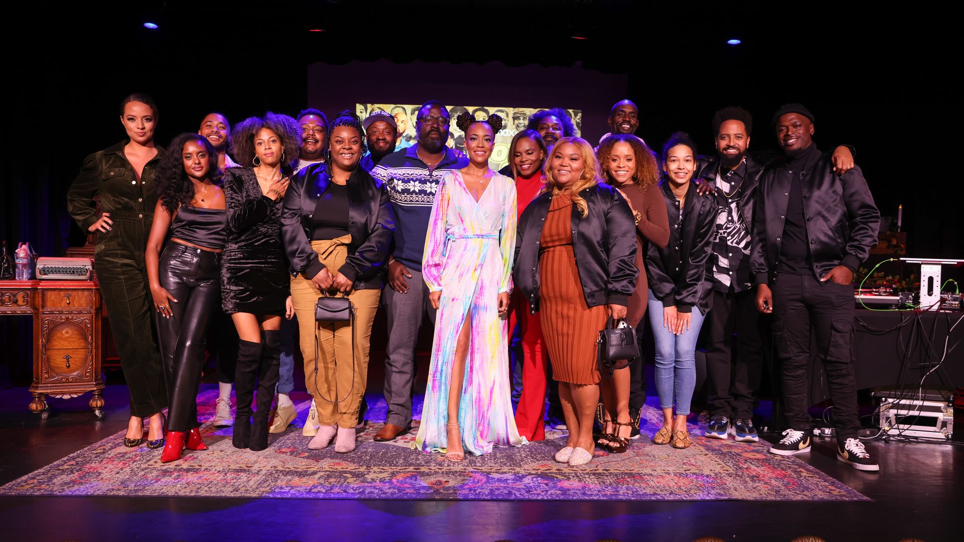 Photo of a group of people posing on a stage for the camera.