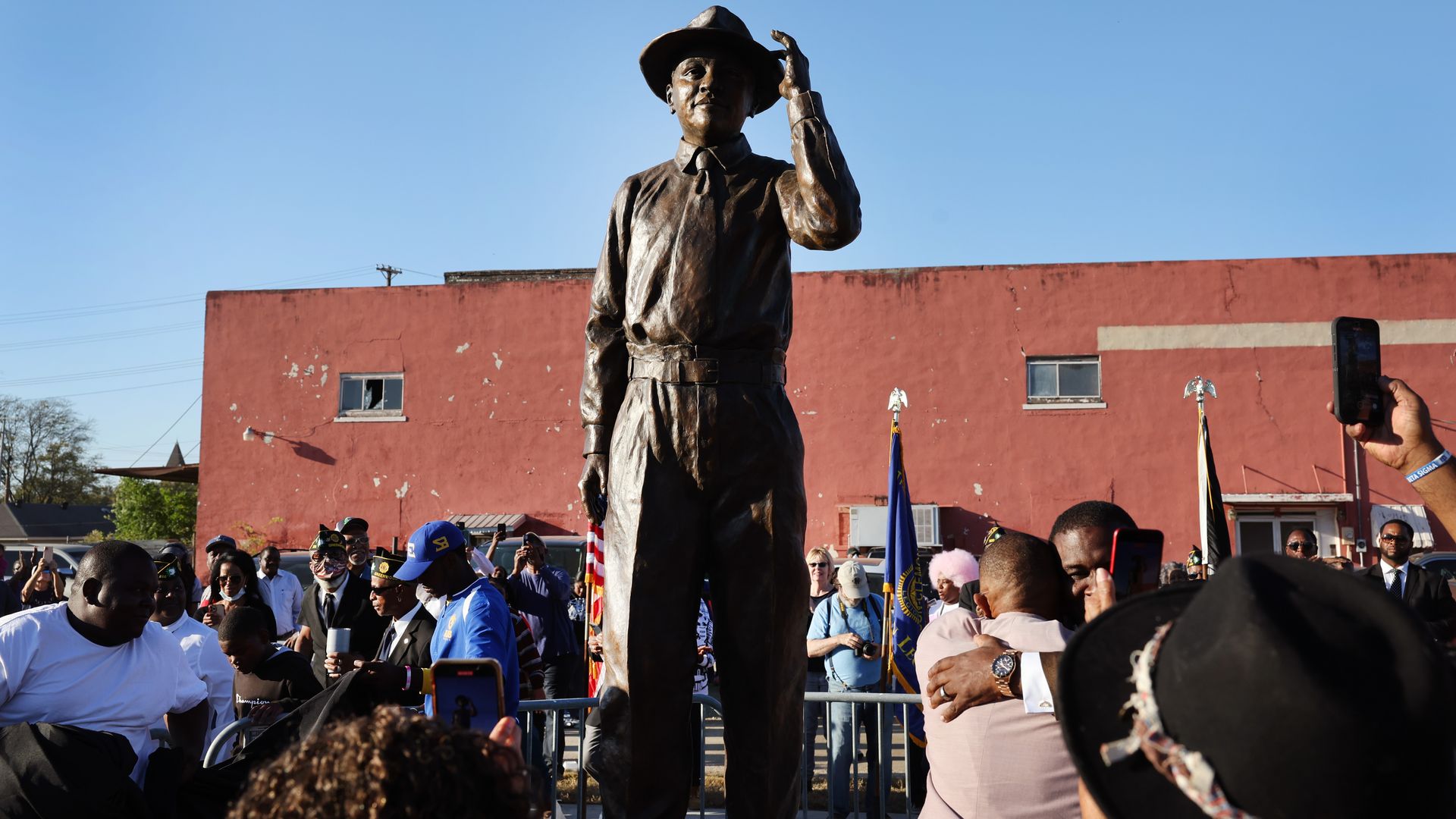 Photo of the status of Emmett Till unveiled in public as people take pictures and embrace