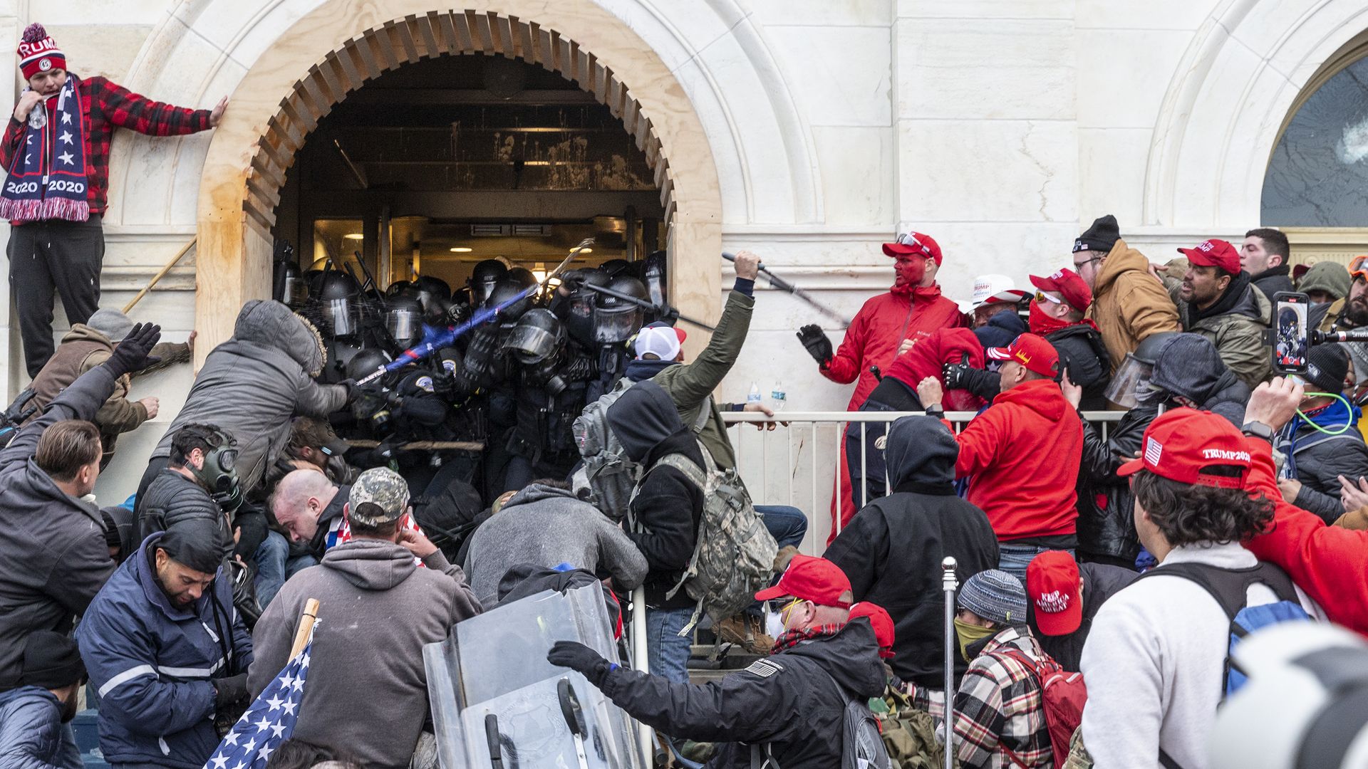 Photo of Capitol rioters crowding a group of Capitol police officers with weapons