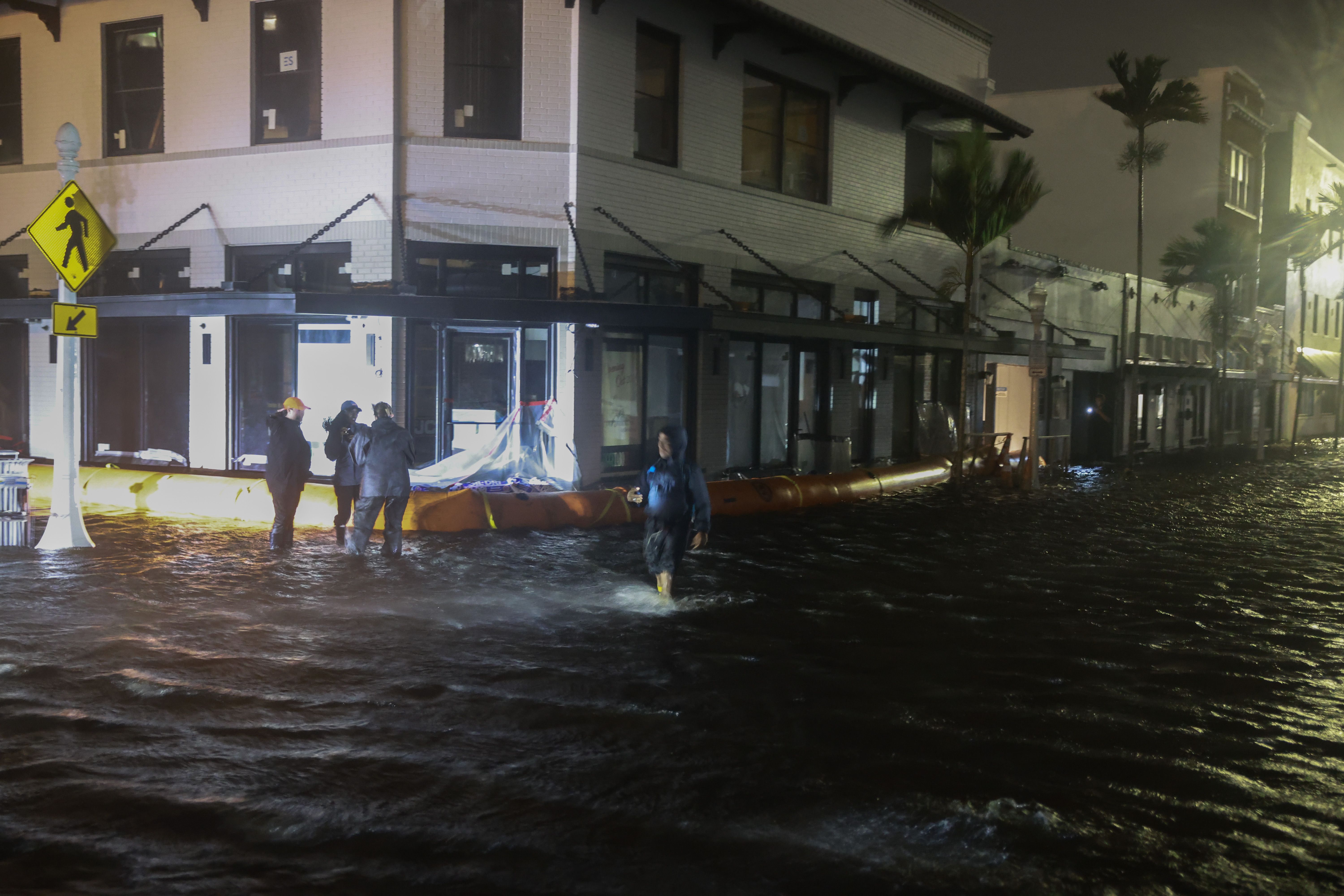 Members of the media work in flooded streets after Hurricane Milton made landfall in the Sarasota area on October 09, 2024, in Fort Myers, Florida. 