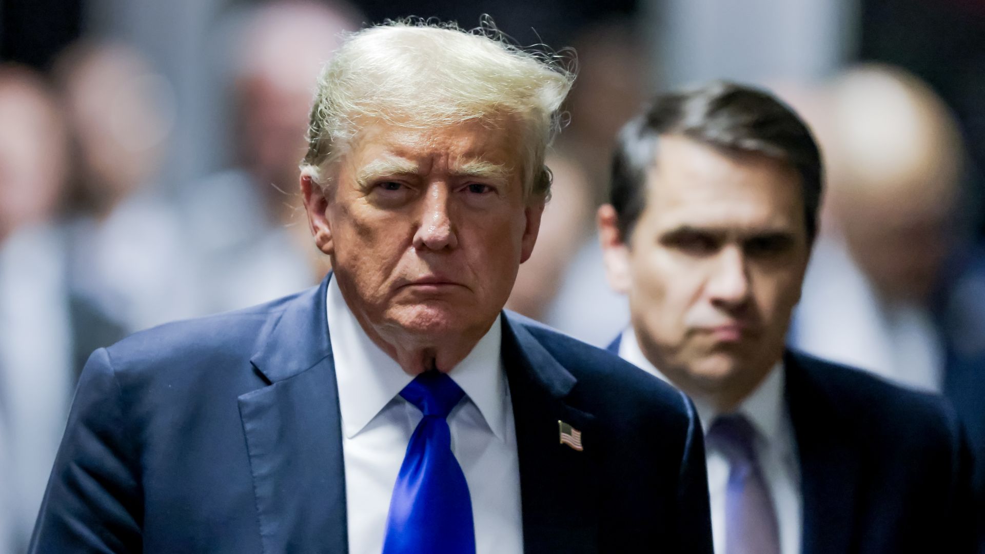 Trump walks out of a New York courtroom, followed by attorney Todd Blanche.