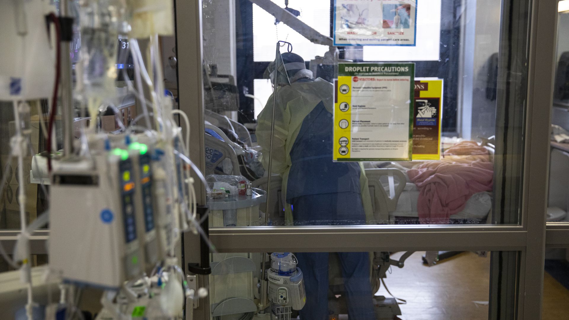 A nurse checks the vital signs of a COVID-19 patient using a ventilator