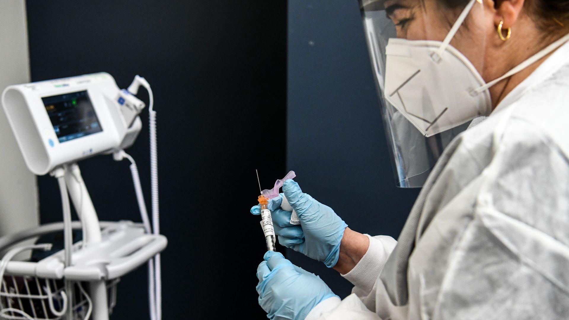 A health care worker a dose of a COVID-19 vaccine now in phase three clinical trials in Hollywood, Florida, in August.