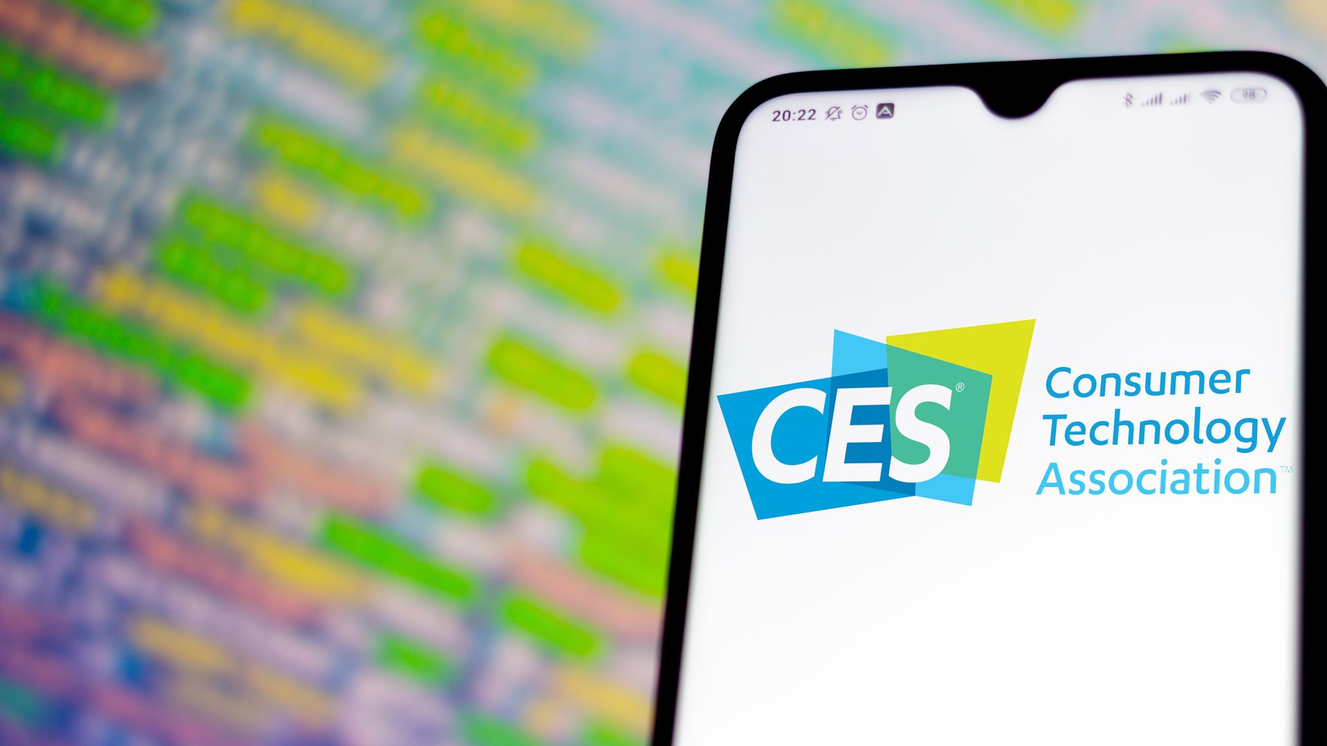 A photo illustration of the CES logo displayed on a smartphone.