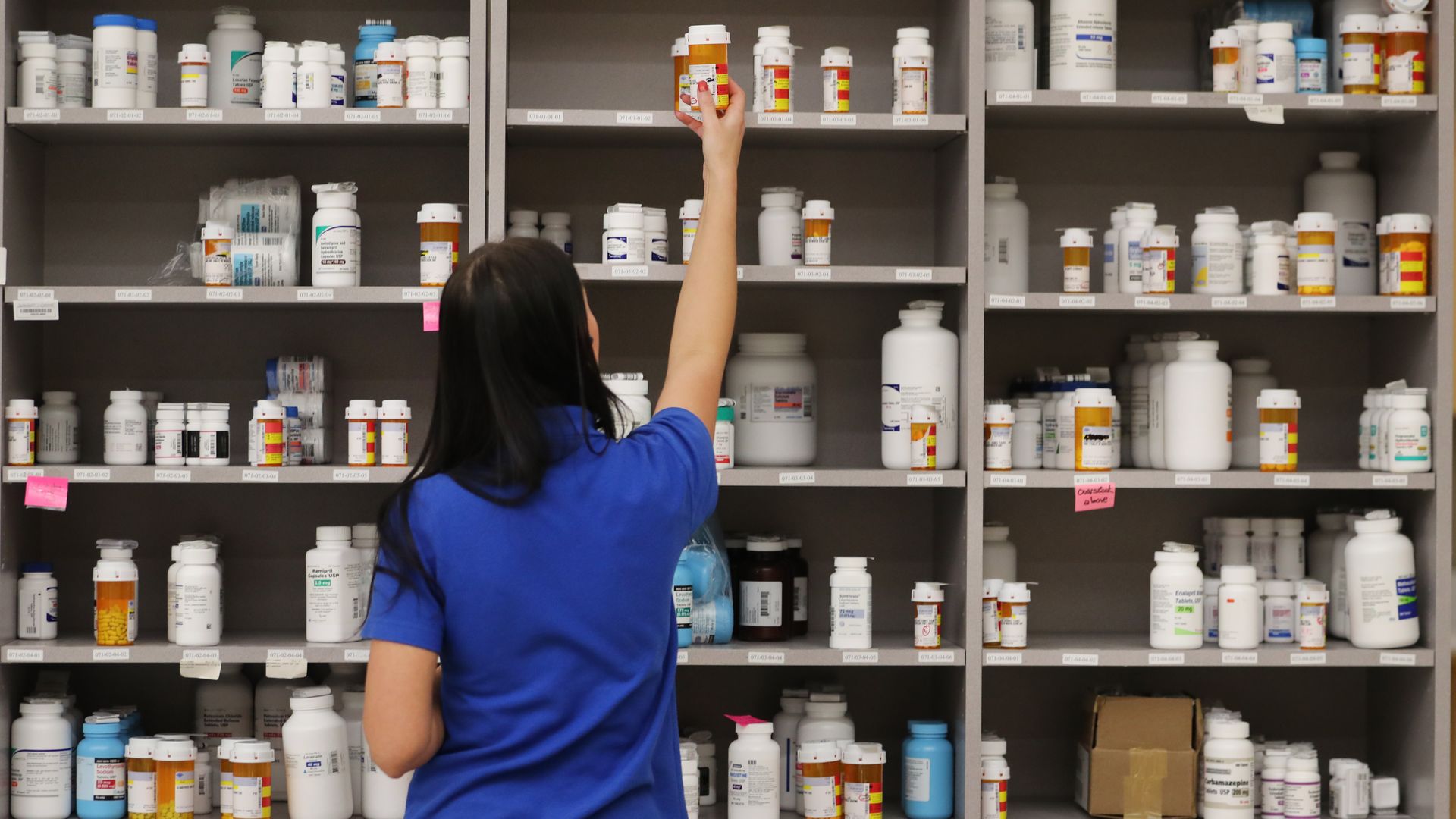 Pharmacist reaching for meds