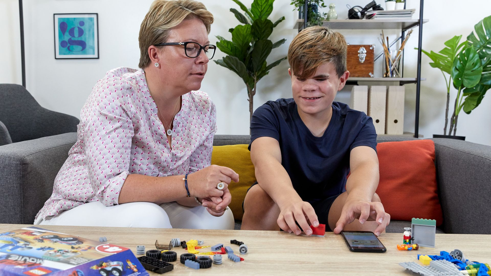 A blind child and an adult build a Lego set using new AI-generated audio building instructions