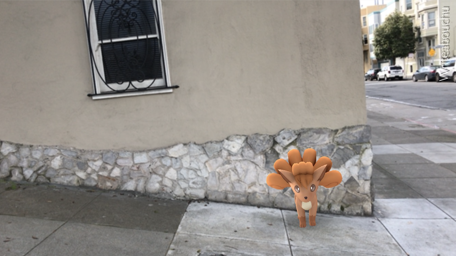 A Vulpix in Pokemon Go next to a house