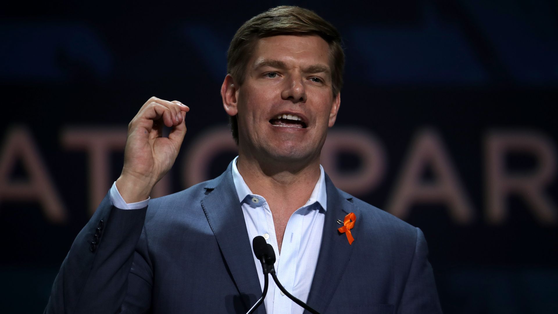 Eric Swalwell standing on stage and speaking into a microphone. 