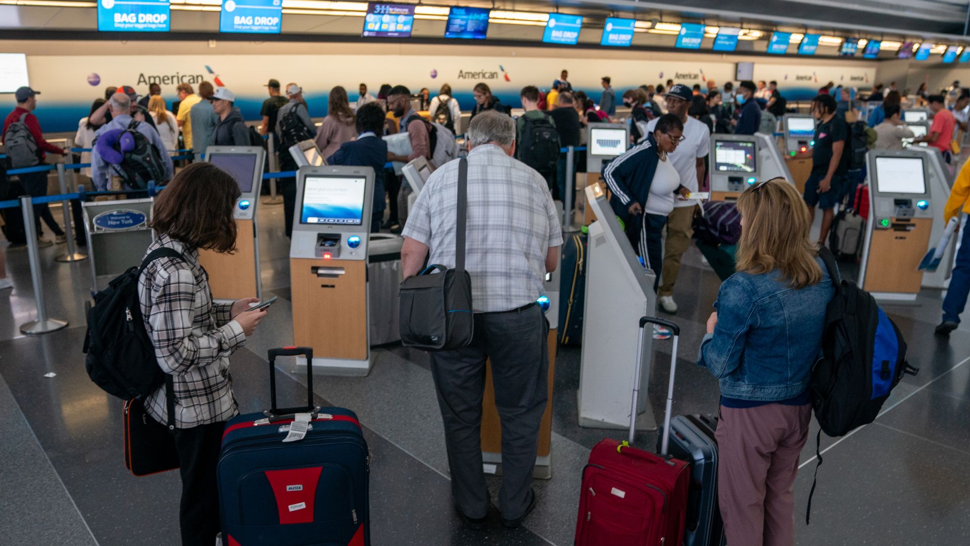 People checkin at the kiosk JFK International airport on June 30