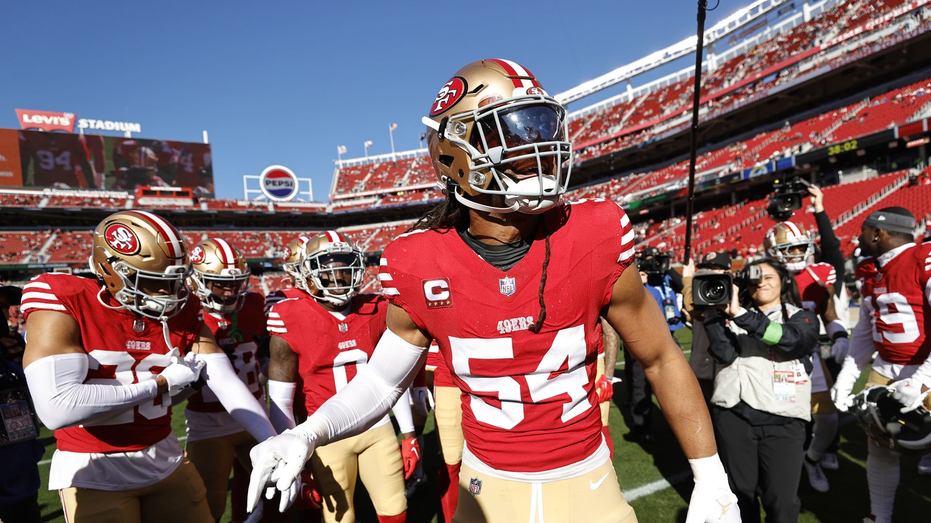 Photo of San Francisco 49ers players in uniform as they rally