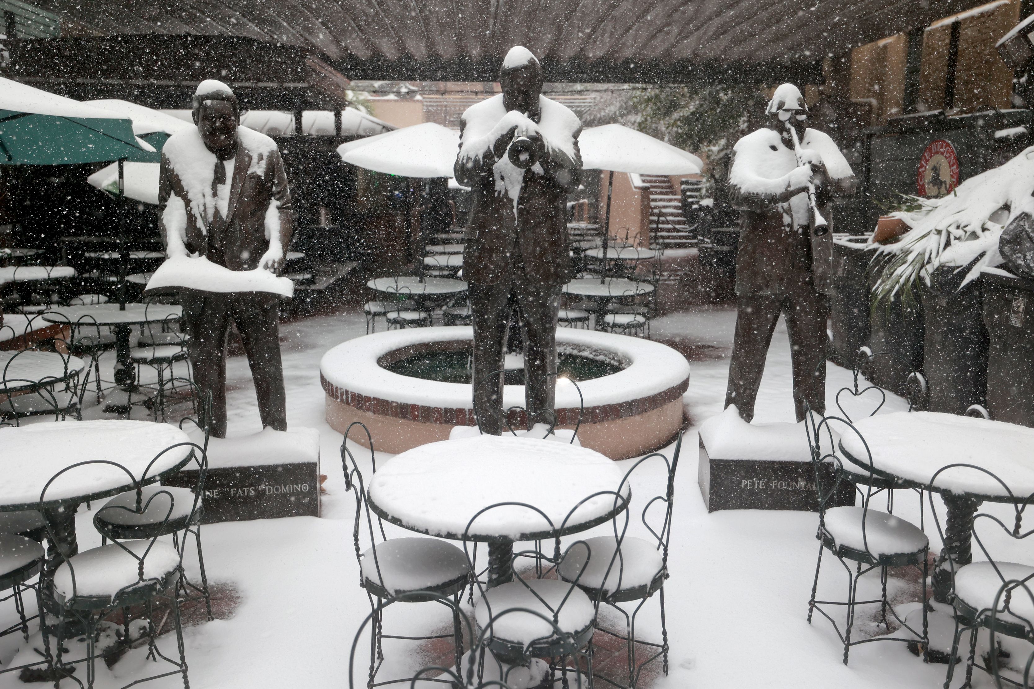 Image shows statues of musicians covered in snow.