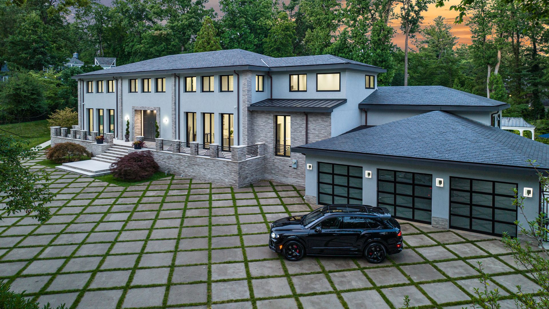 A sprawling white mansion, with a car parked out front.