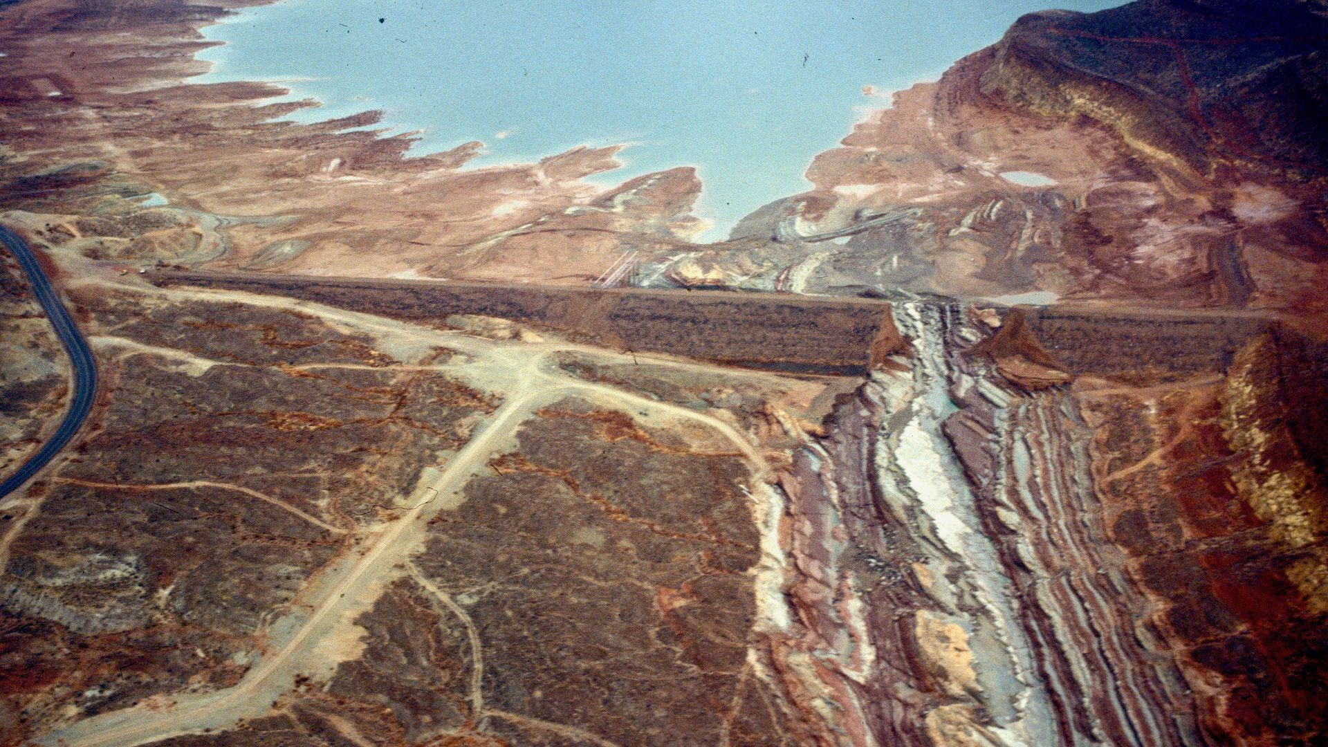 An aerial view of a dike after it breached at a desert reservoir.