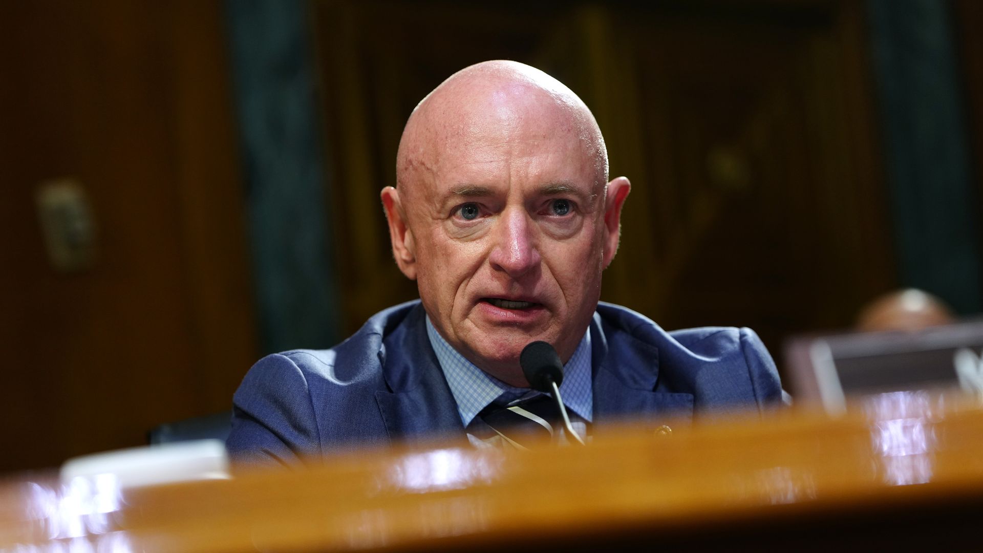 Arizona Sen. Mark Kelly is shown behind a desk.