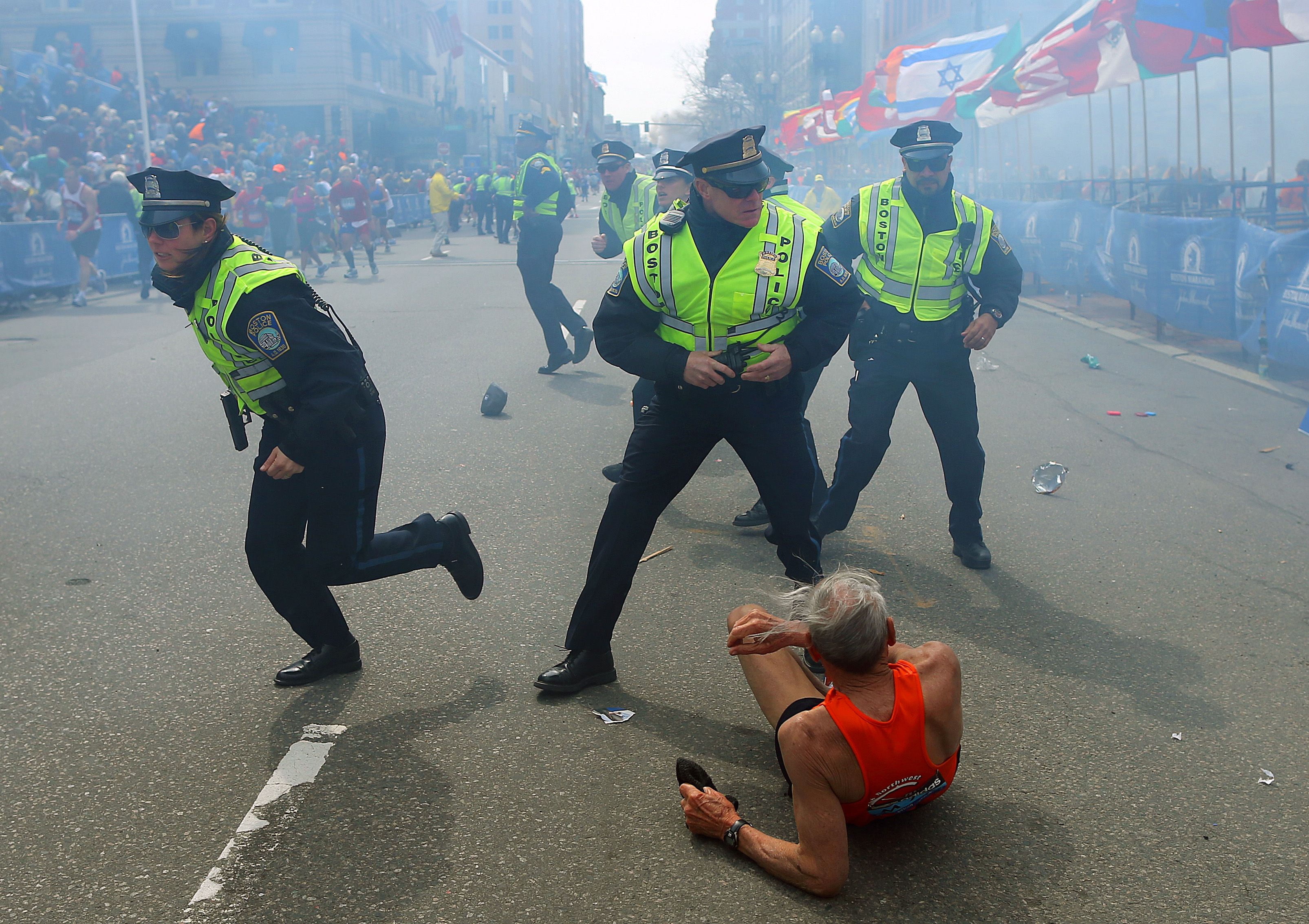 Police officers with their guns drawn hear the second explosion at the Boston Marathon in 2013