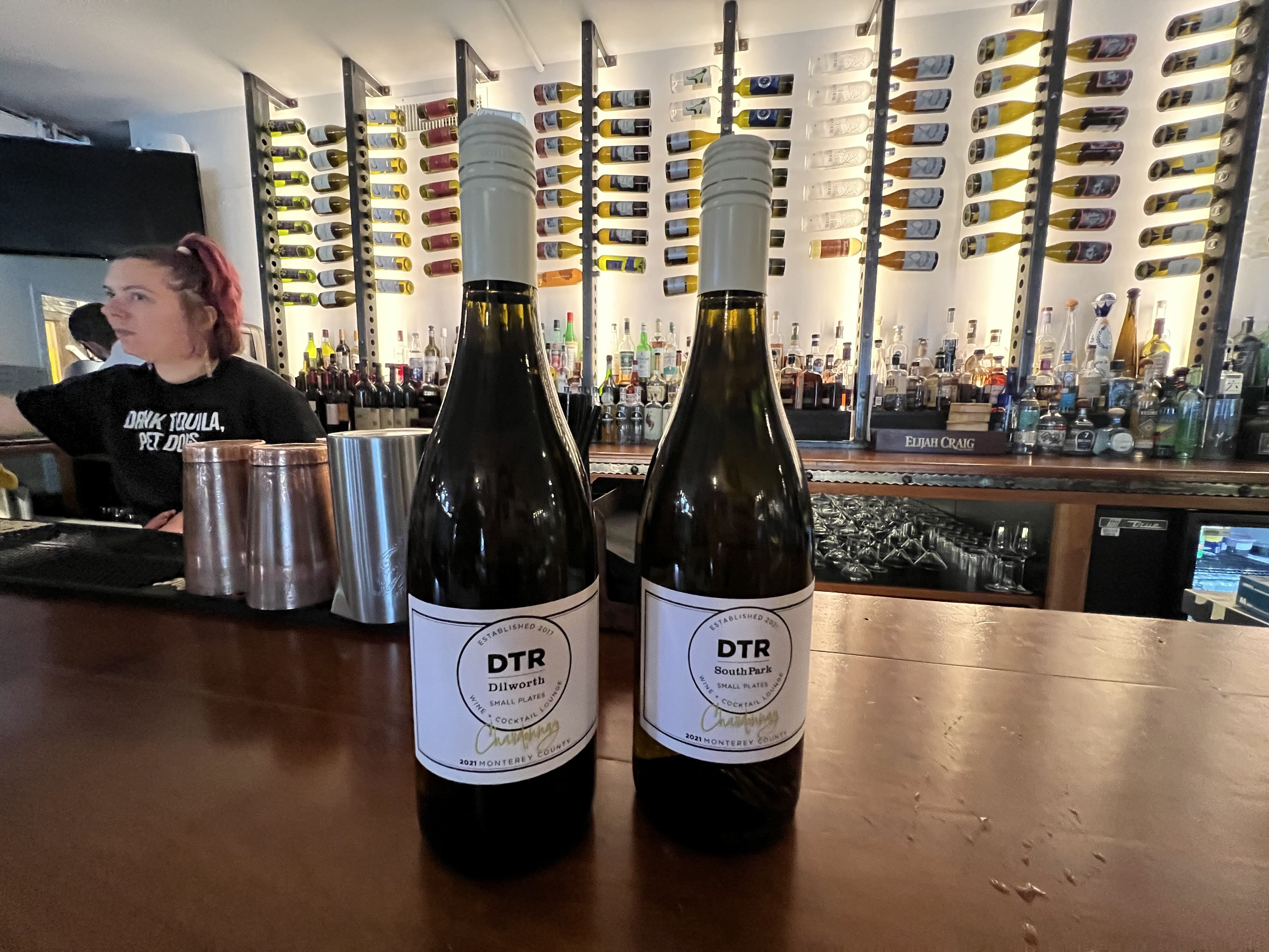 two wine bottles on a bar
