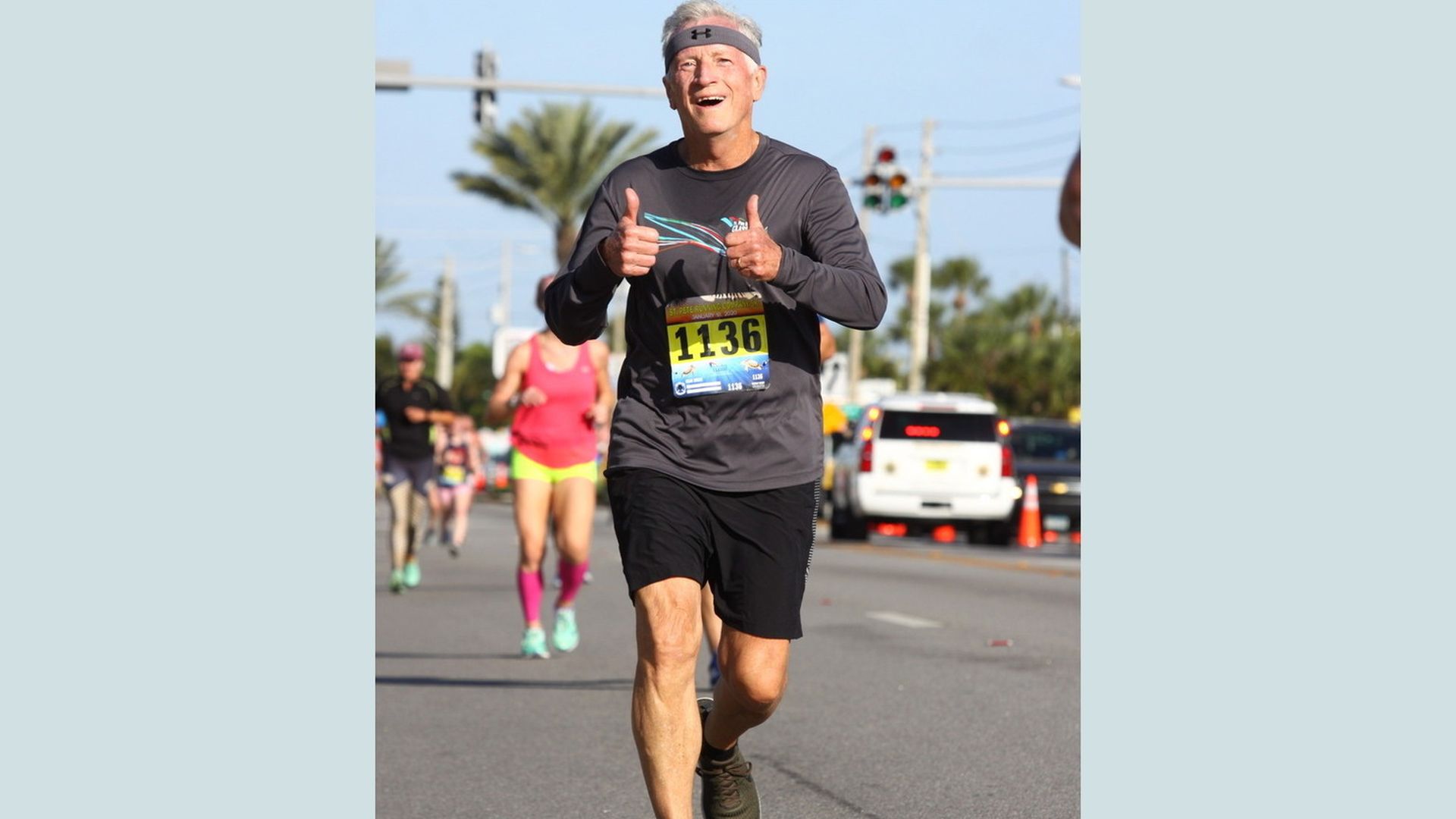 Alan Grofé running with a smile and two thumbs up 