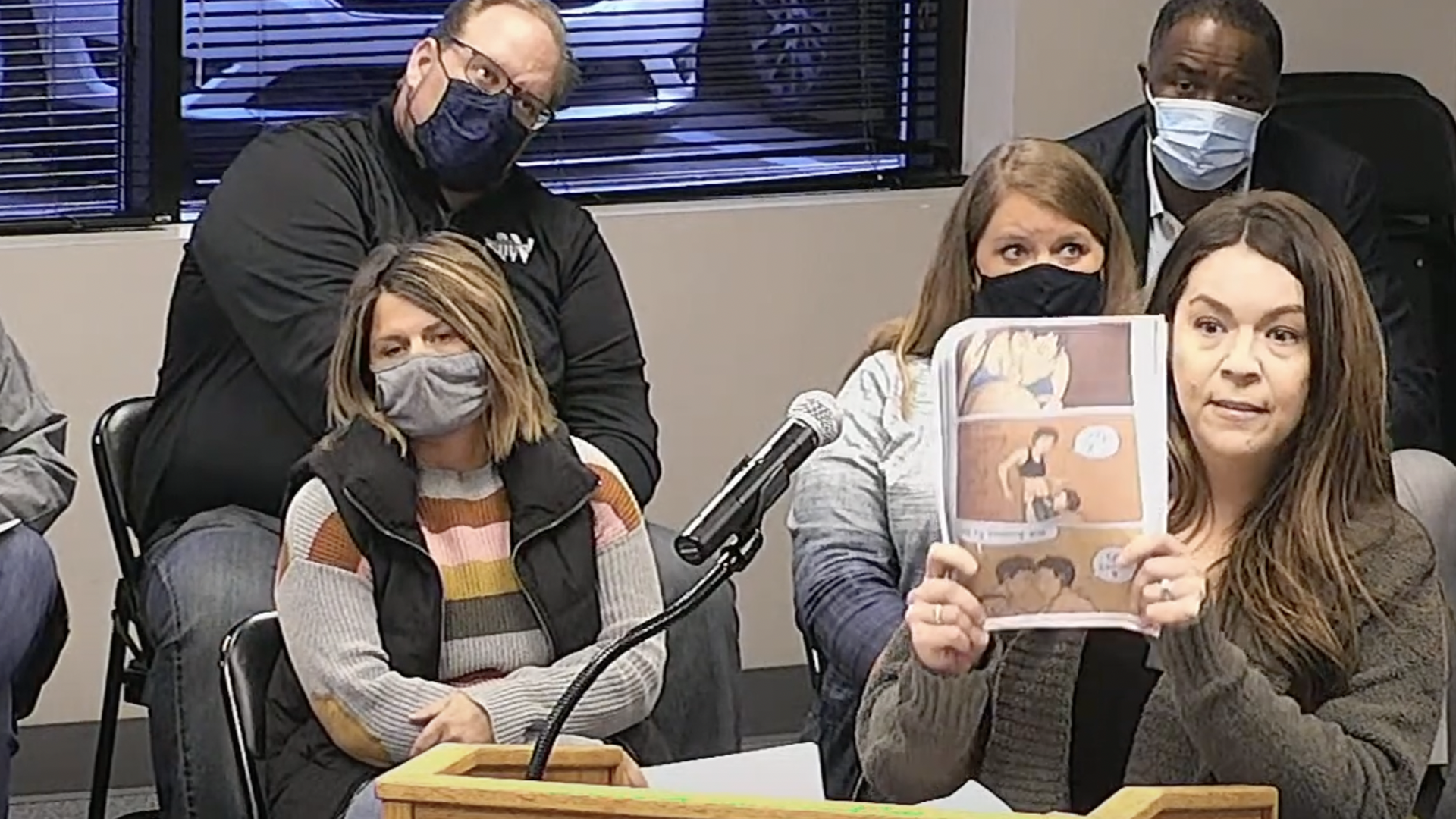 A Waukee community member holds up a graphic novel depicted oral sex.