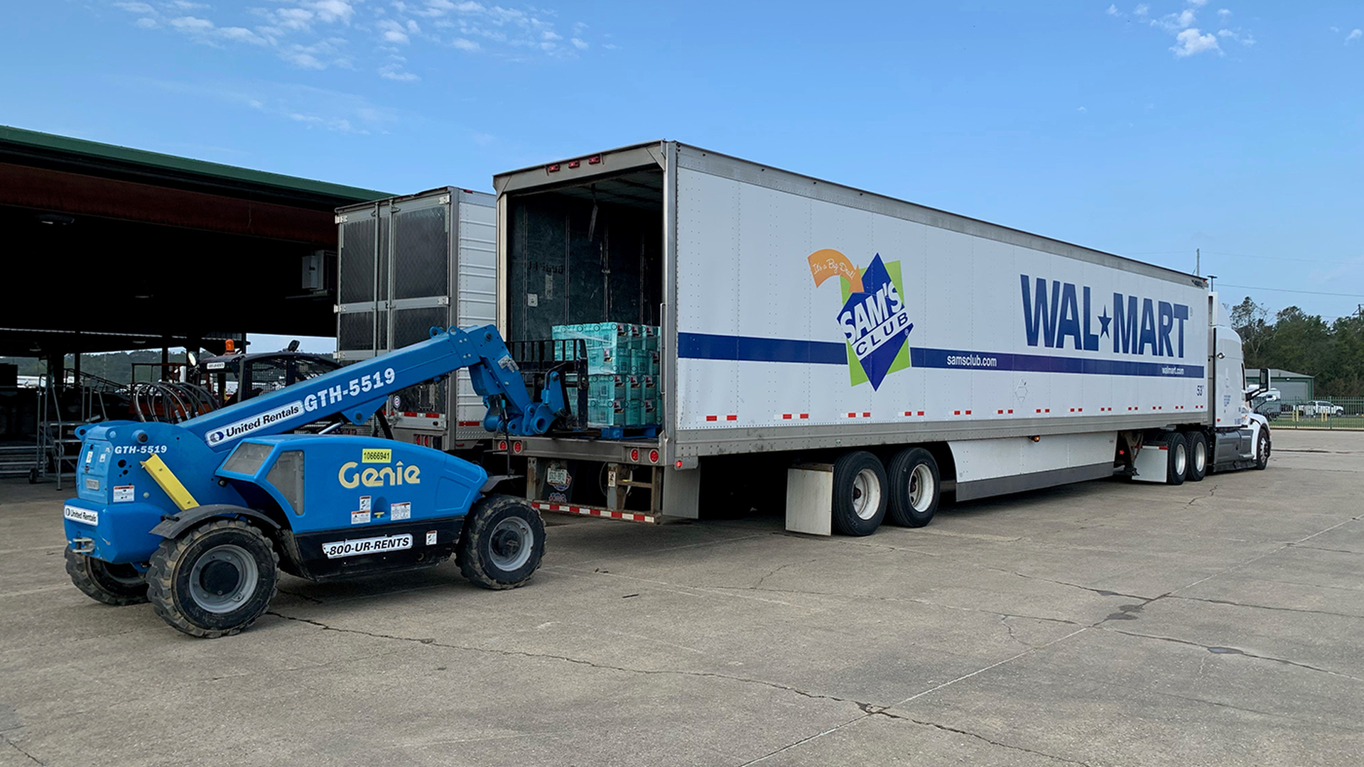 A forklift loads a Walmart truck with supplies. 